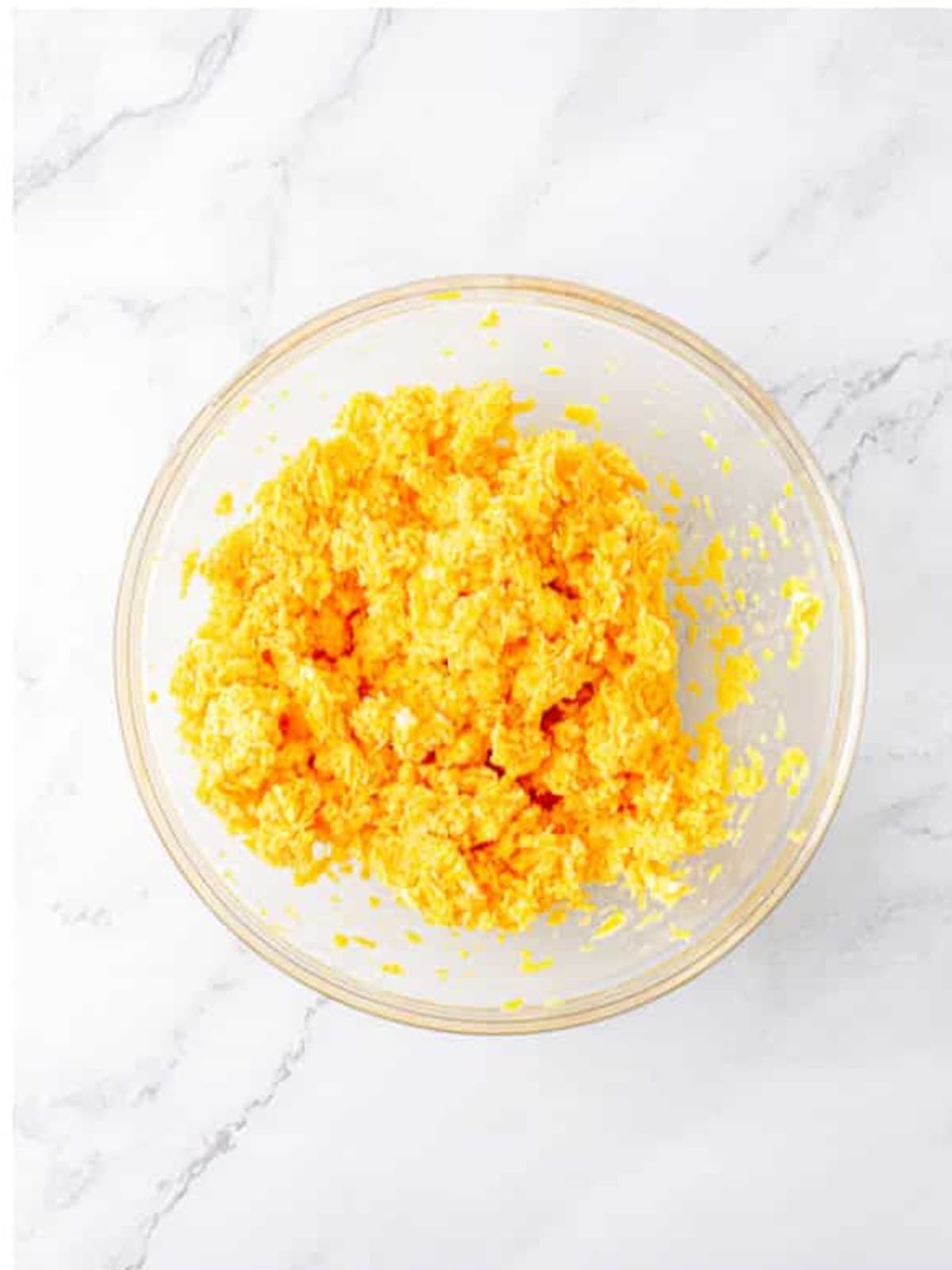 Whipping butter and shredded cheddar cheese together until fluffy.