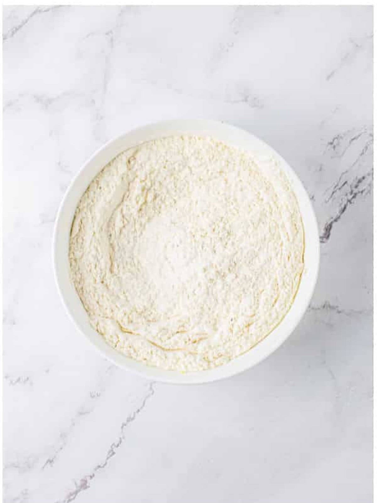 Sifted flour with chipotle powder and seasonings for cheese straws.