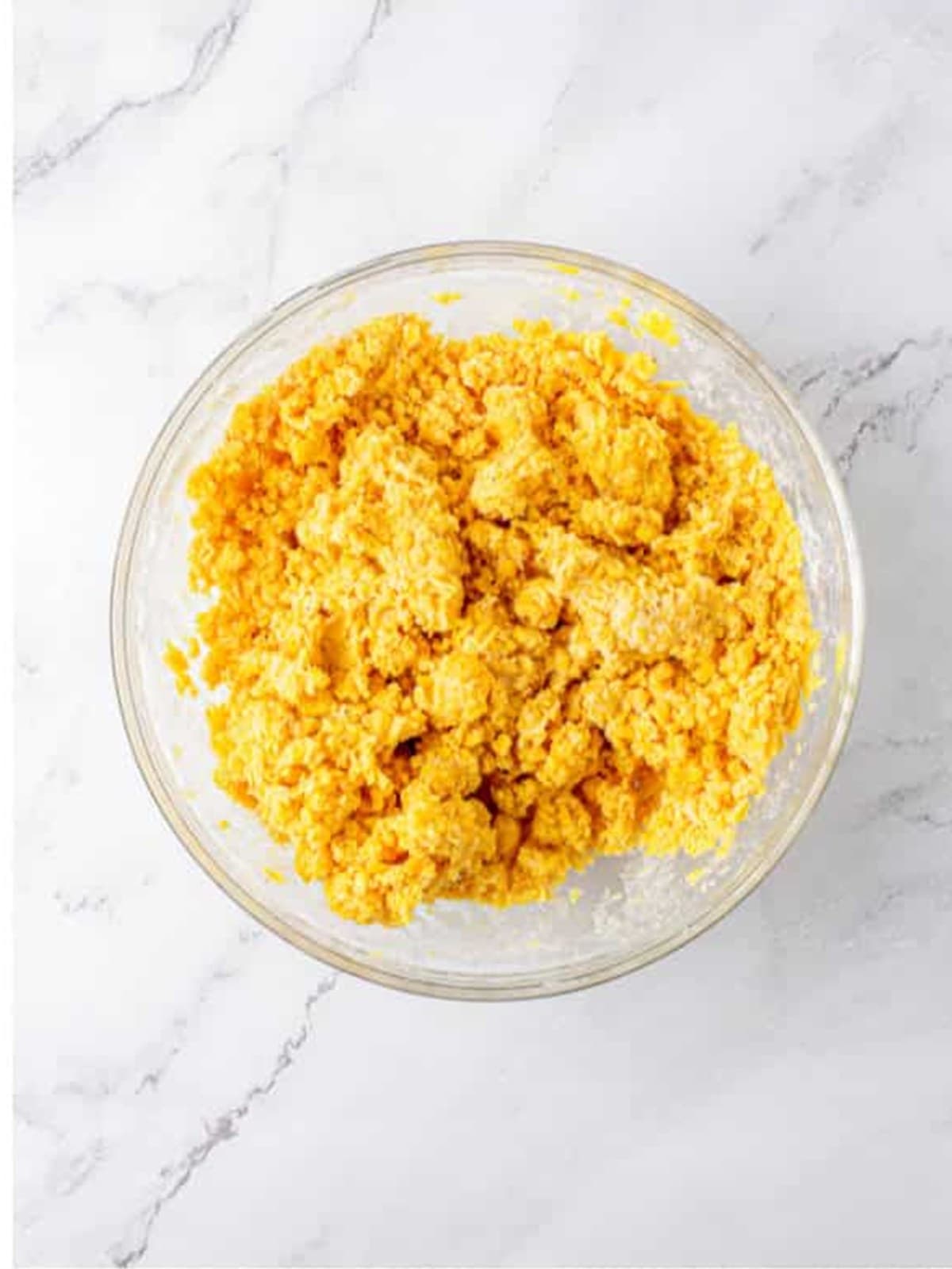 Soft cheese straw dough mixed in a glass bowl.