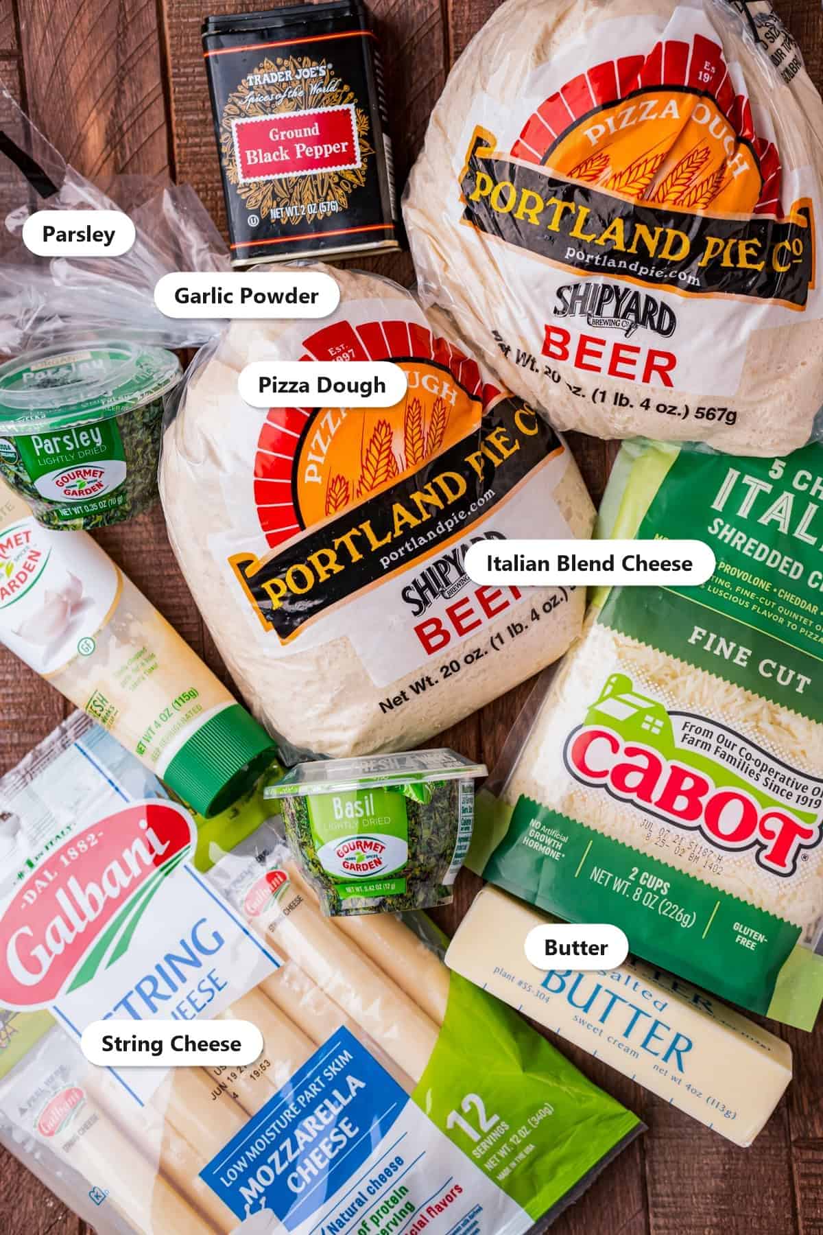 Labeled ingredients for cheese stuffed breadsticks including pizza dough, string cheese, Italian blend cheese, butter, garlic powder, and parsley.