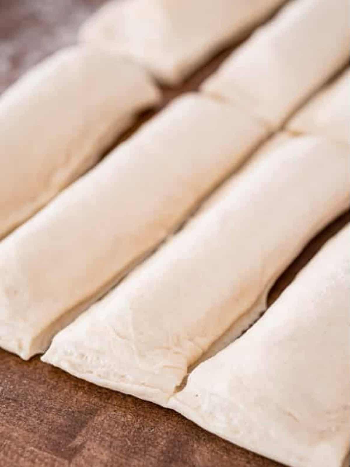 Cheese stuffed breadsticks cut into individual pieces with a pizza cutter.