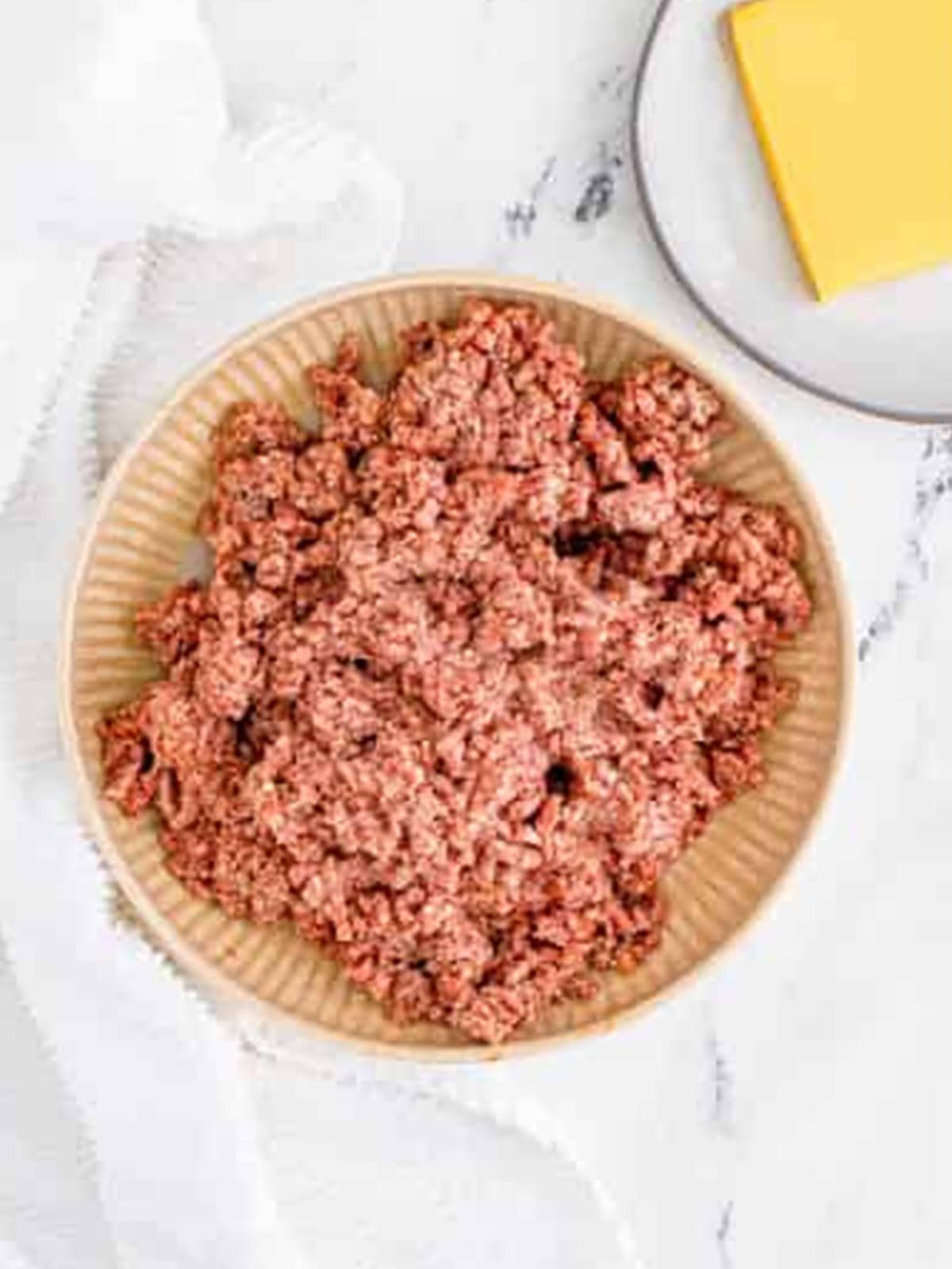 Seasoned ground beef mixed together by hand for cheeseburger patties.
