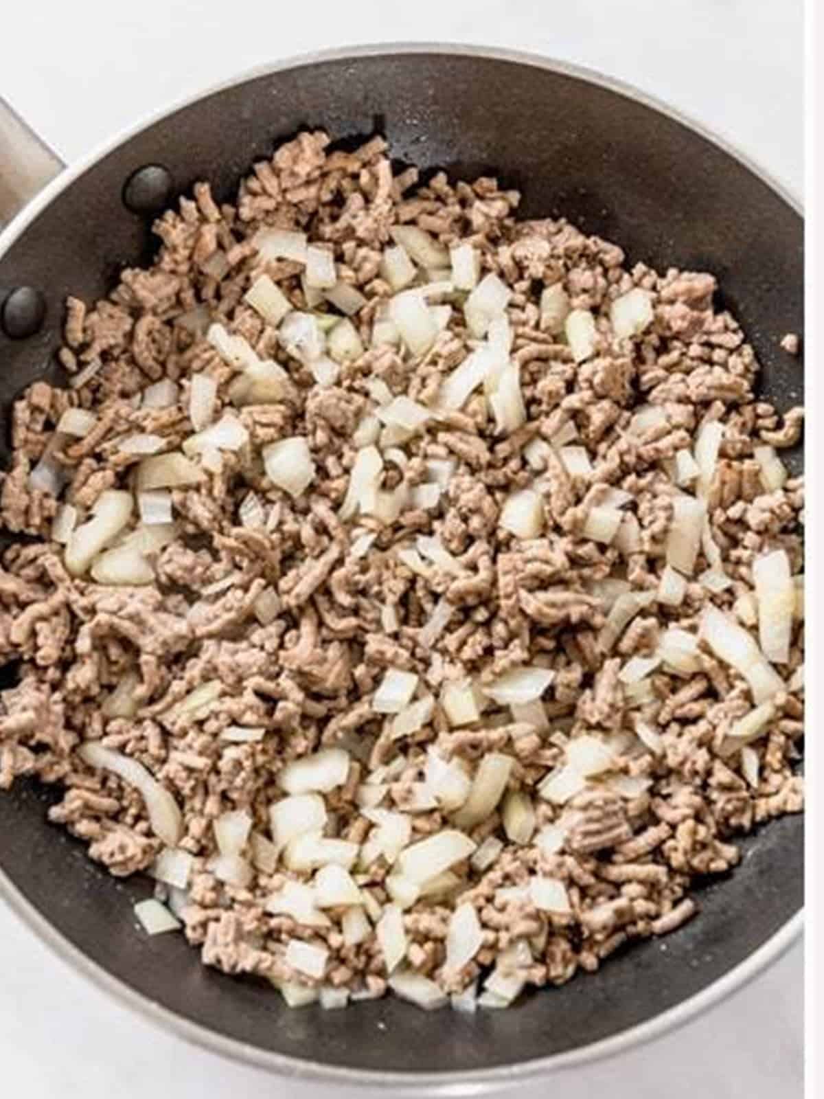 Browning ground beef and onion in a skillet for Cheeseburger Pasta.