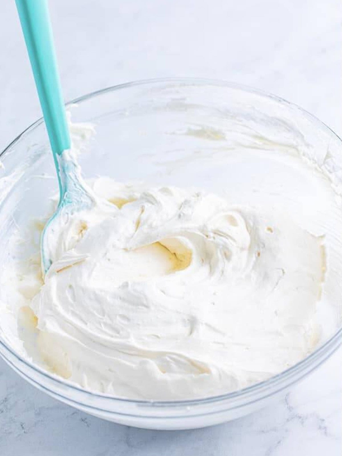 Fluffy cheesecake dip mixture folded together with a spatula before chilling.