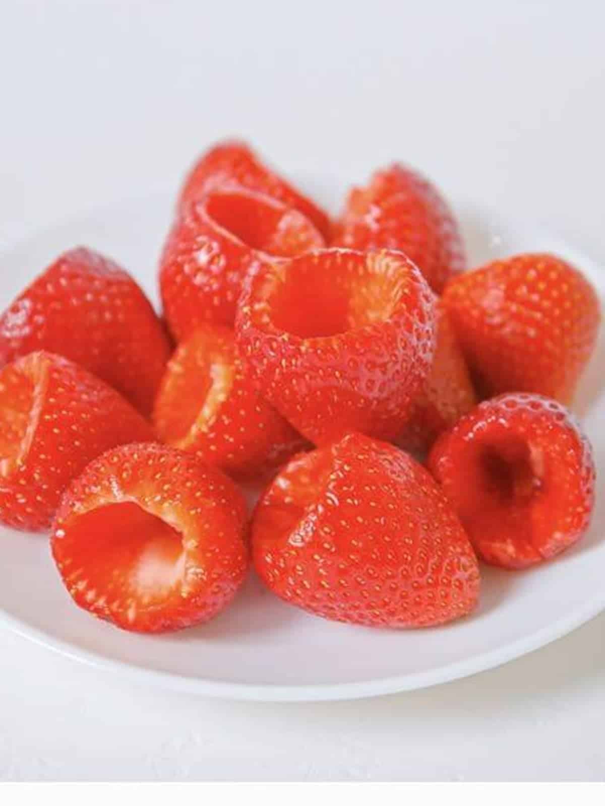 Fresh strawberries with the centers cut out, ready to be filled.