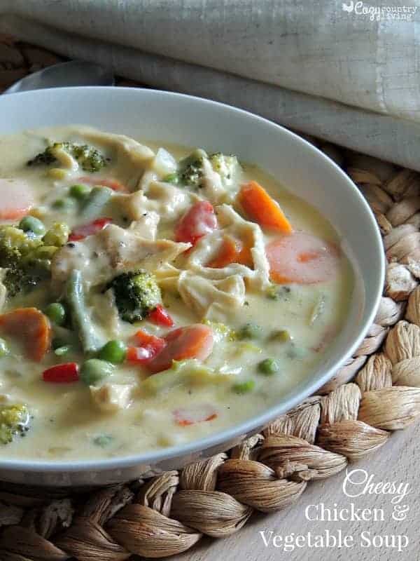 Cheesy chicken vegetable soup served warm in a bowl.