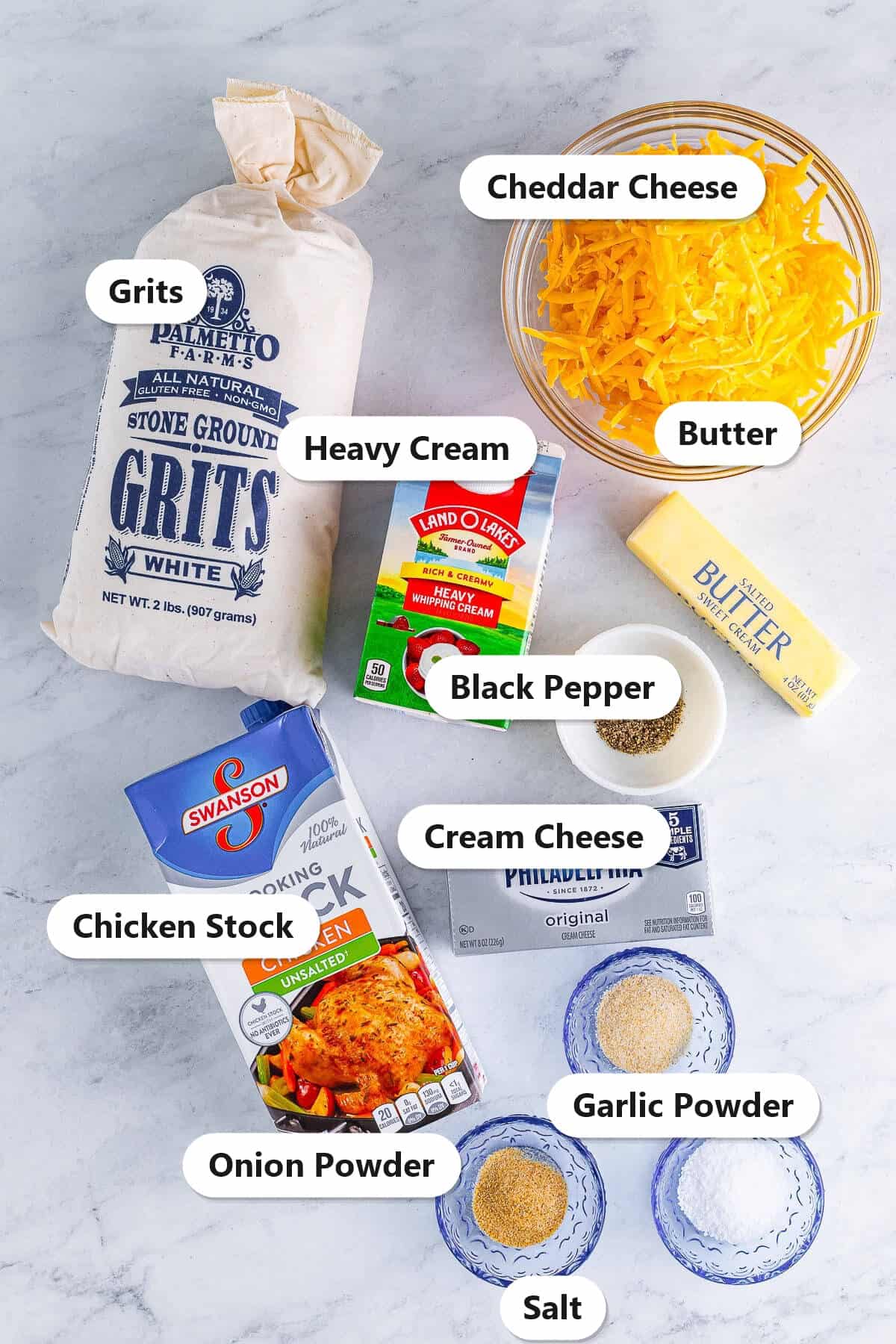 Labeled cheesy grits ingredients including stone ground grits, cheddar cheese, heavy cream, chicken stock, cream cheese, butter, and spices.