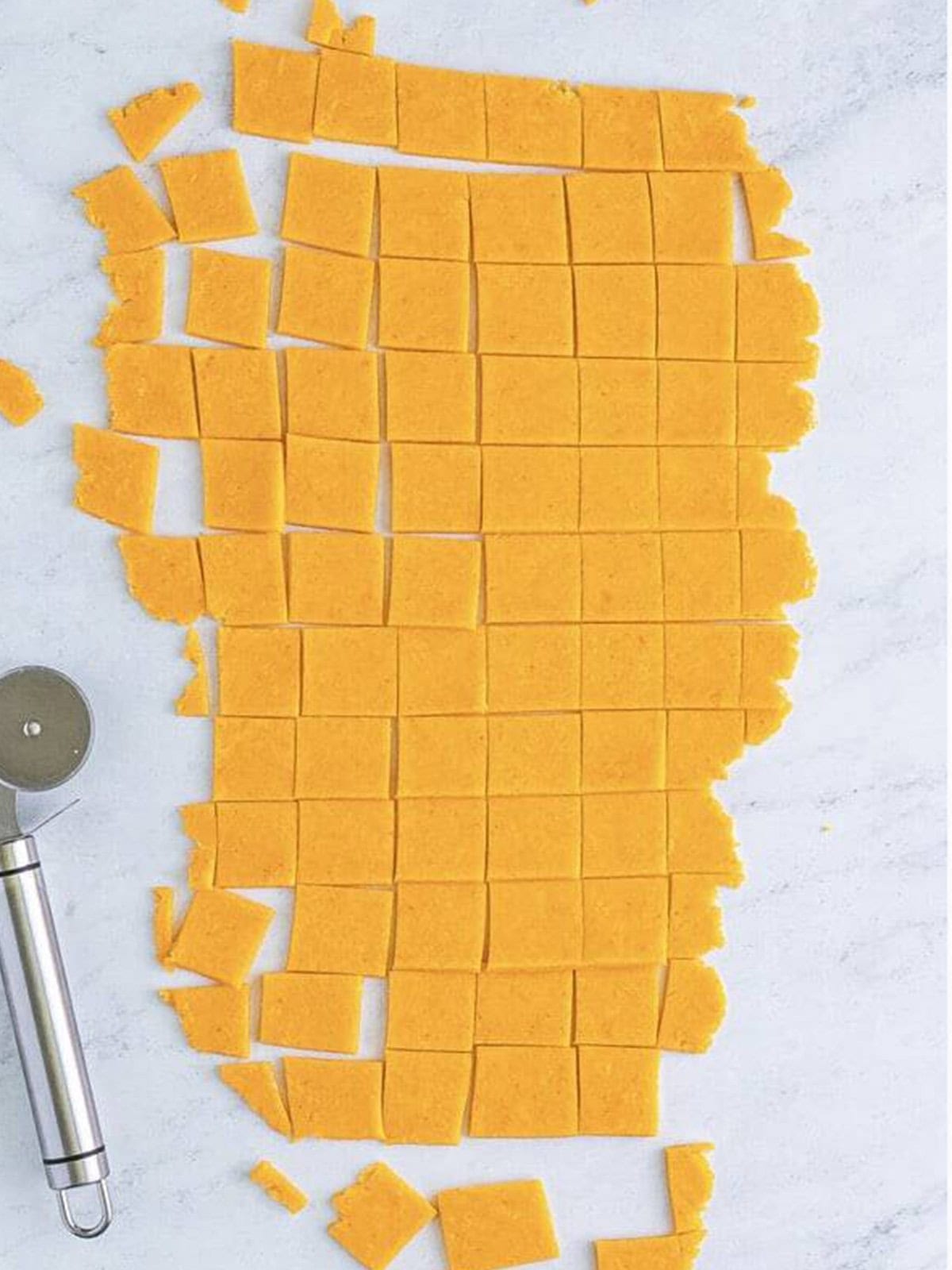 Cracker dough cut into one-inch squares with a pizza cutter.