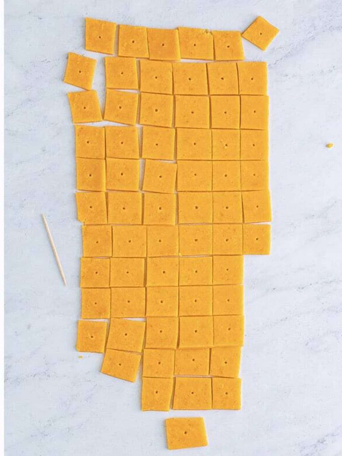 A hole poked into the center of each homemade Cheez-It cracker square.