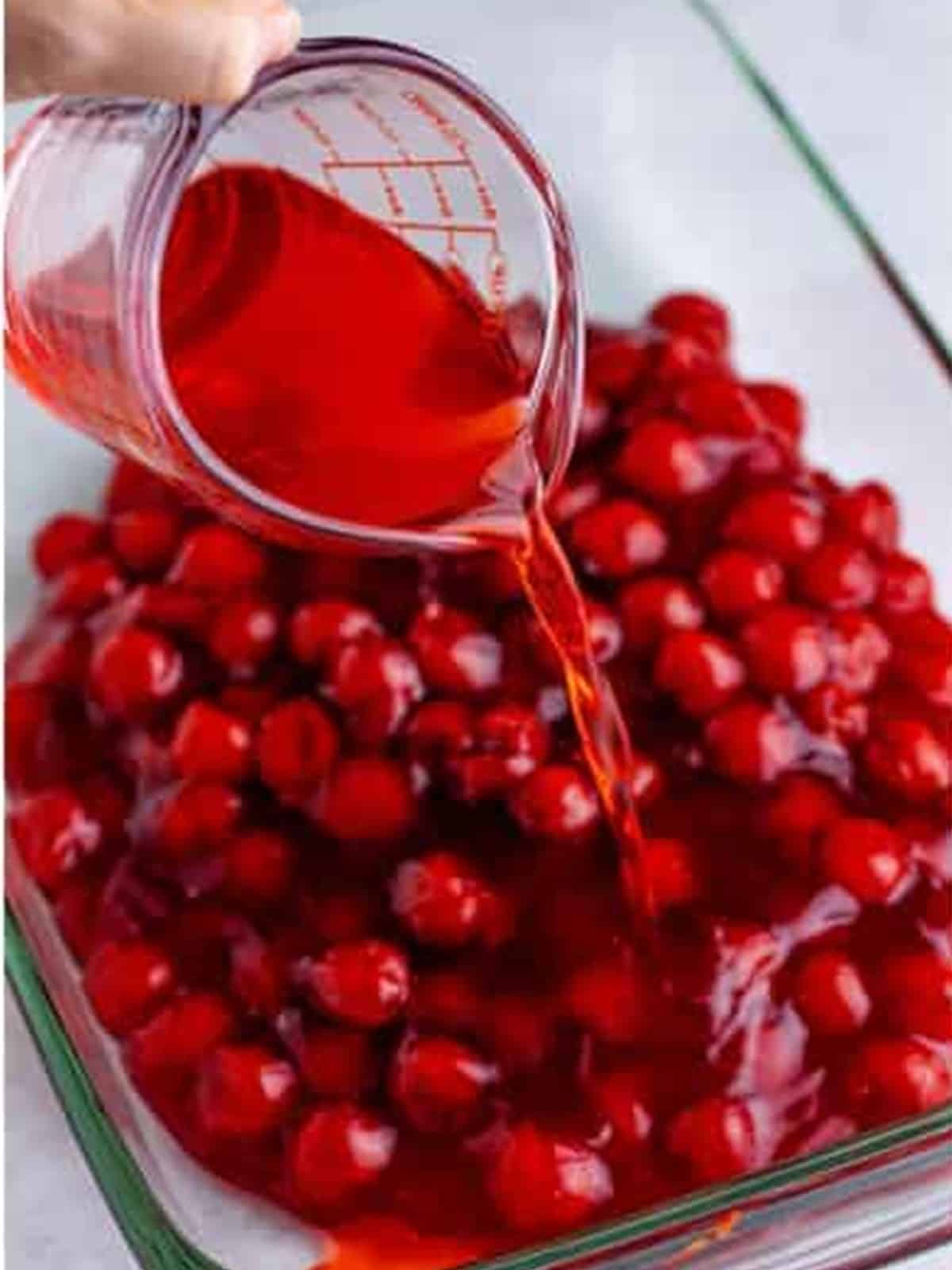 Cherry pie filling poured into a 9x13 glass baking dish for cherry dump cake.