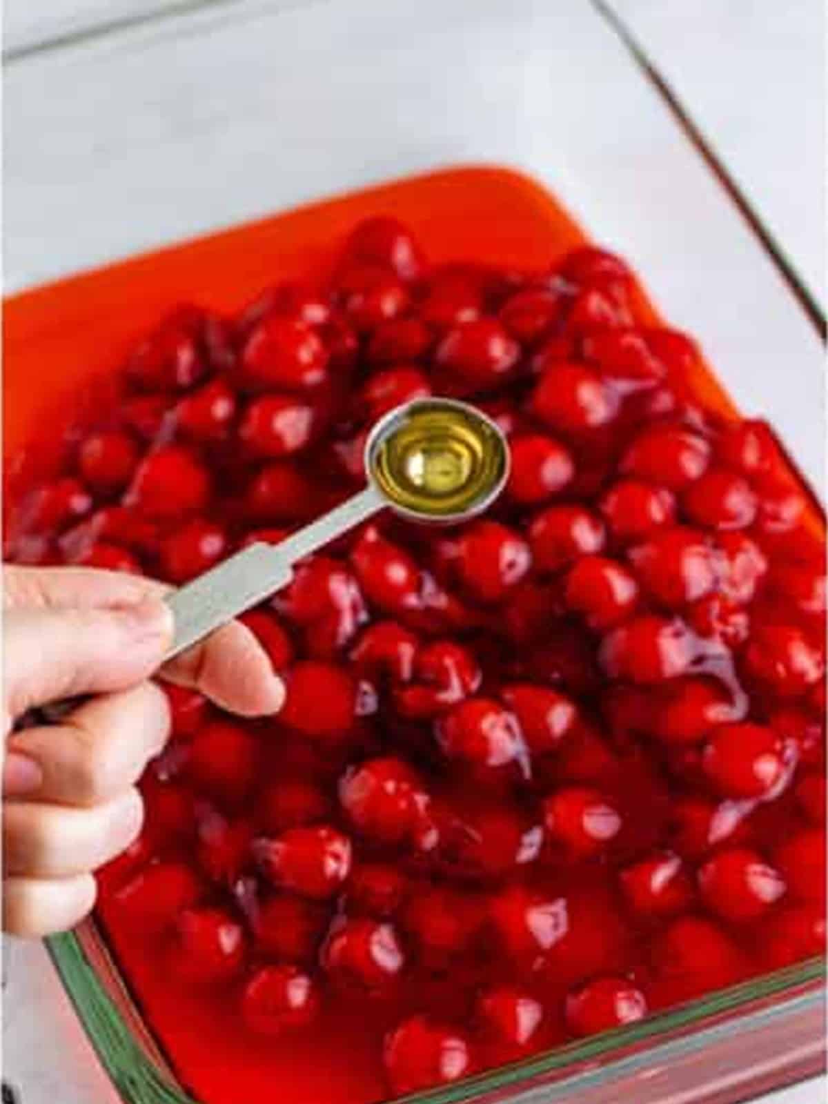 Maraschino cherry juice being added to the cherry pie filling.