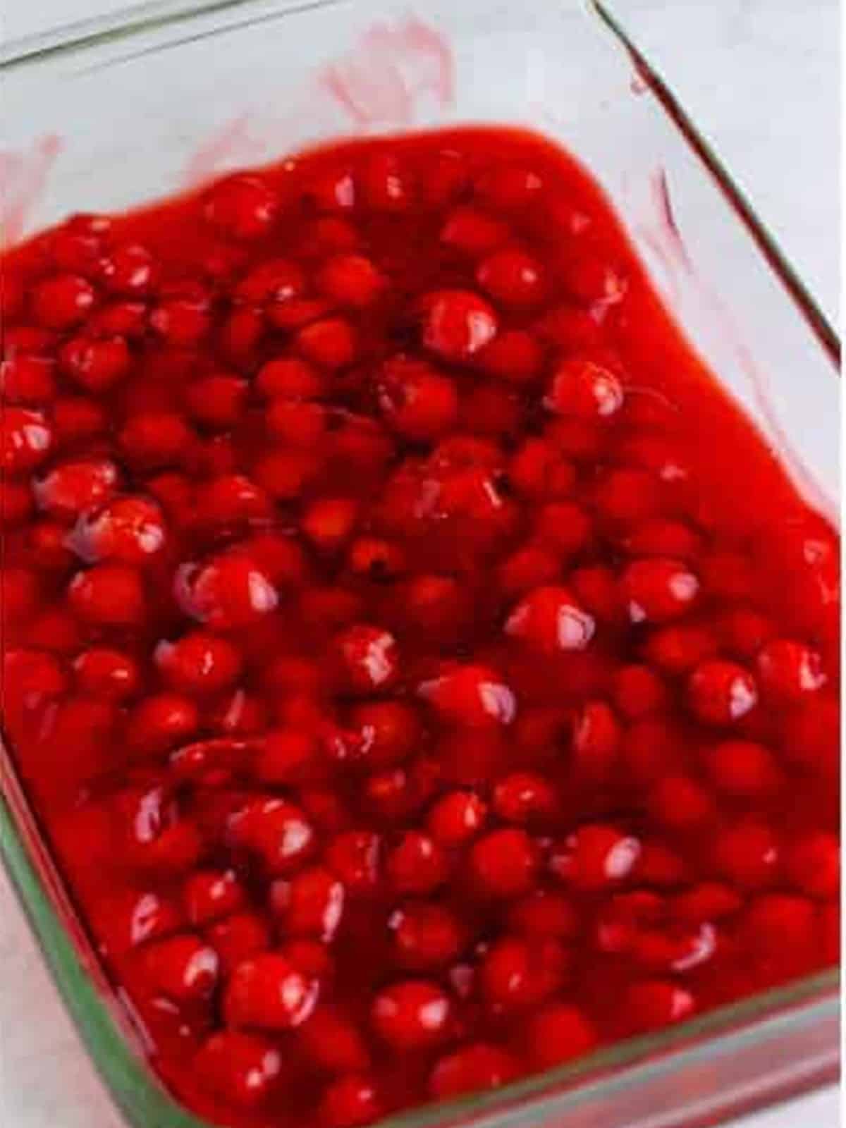 Cherry filling smoothed into an even layer in the baking dish.