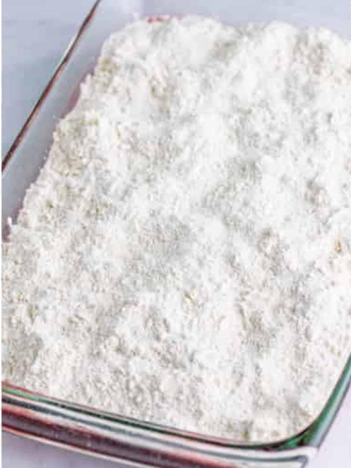 Yellow cake mix sprinkled evenly over the cherry filling.