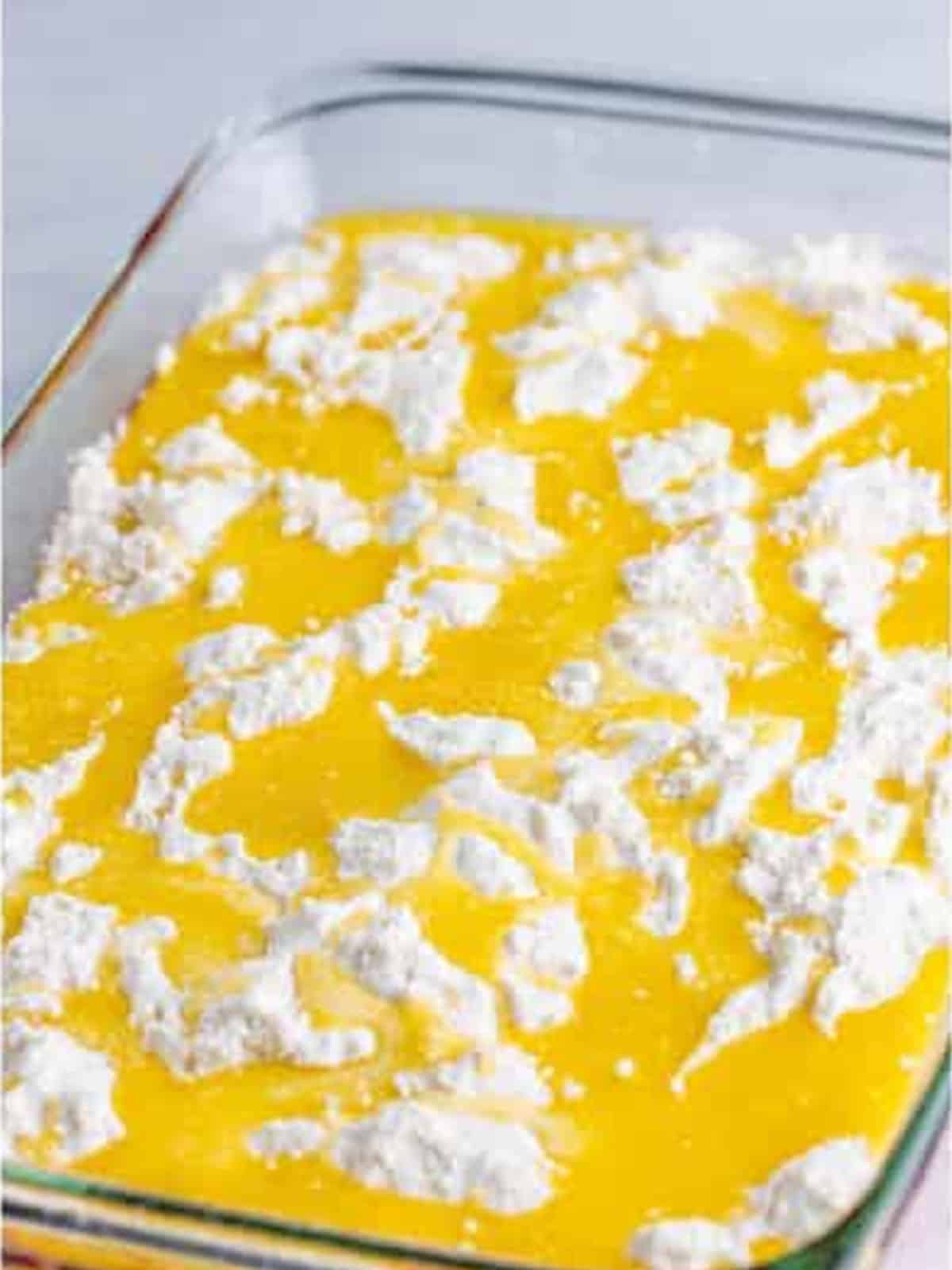 Melted butter poured over the cake mix layer of the cherry dump cake.