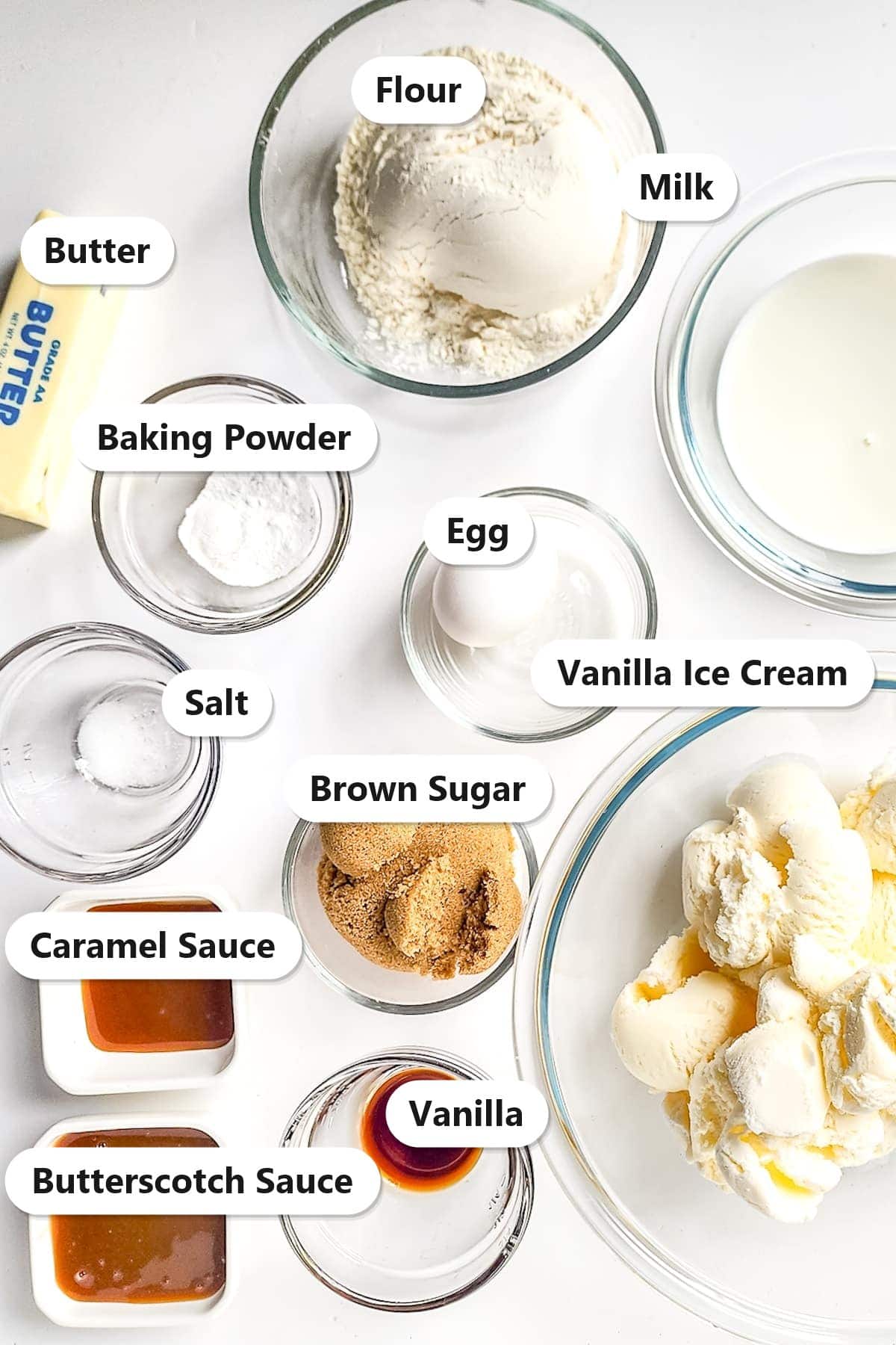 Labeled ingredients for a Chick Fil A milkshake: flour, butter, milk, baking powder, egg, salt, brown sugar, vanilla ice cream, caramel sauce, vanilla, and butterscotch sauce.