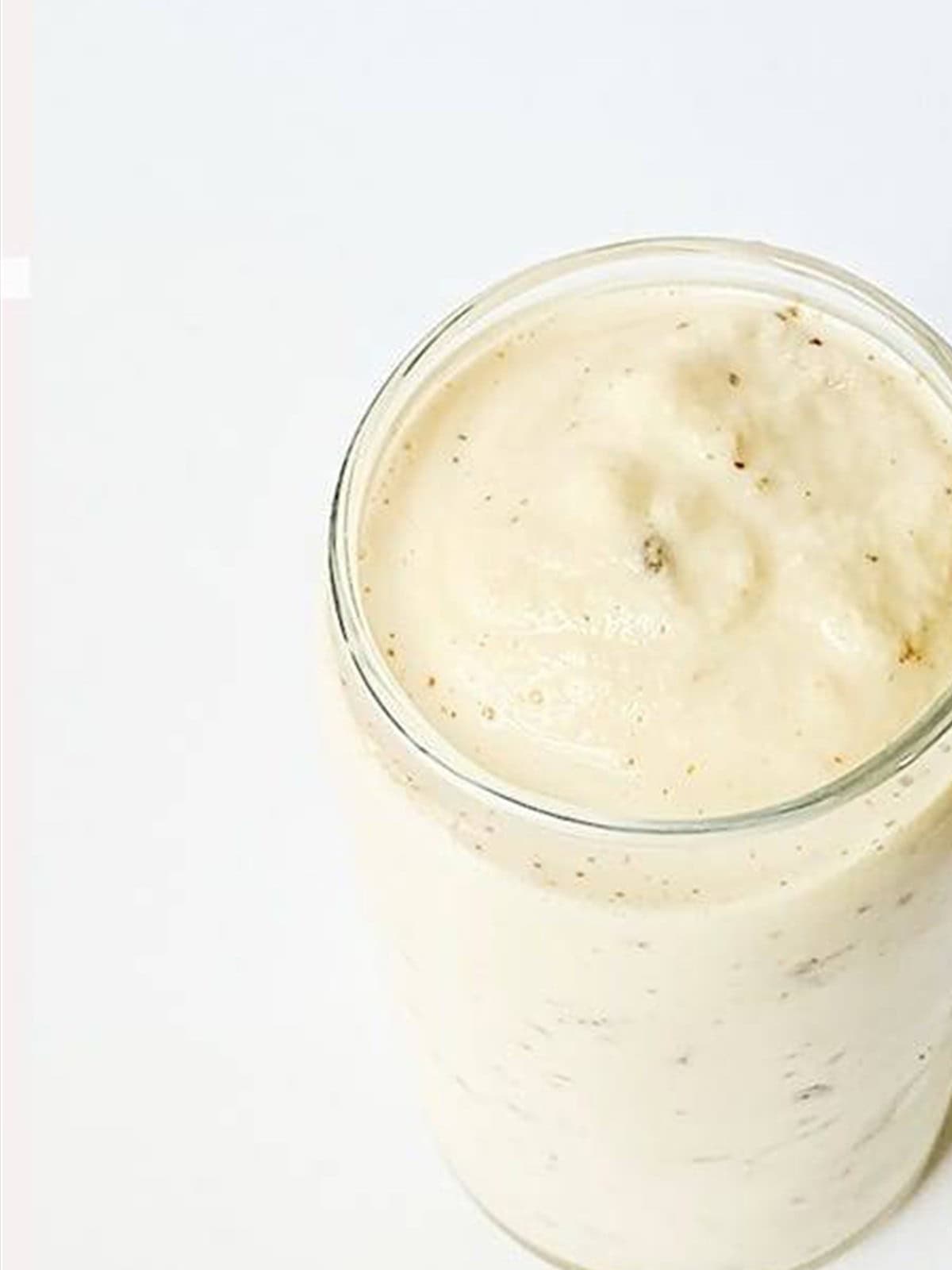 A blended caramel milkshake in a tall glass.