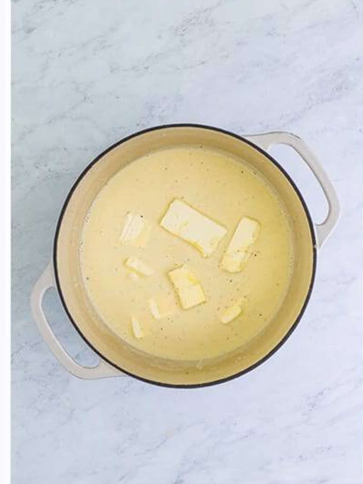 Cubes of cream cheese melting into the alfredo sauce.