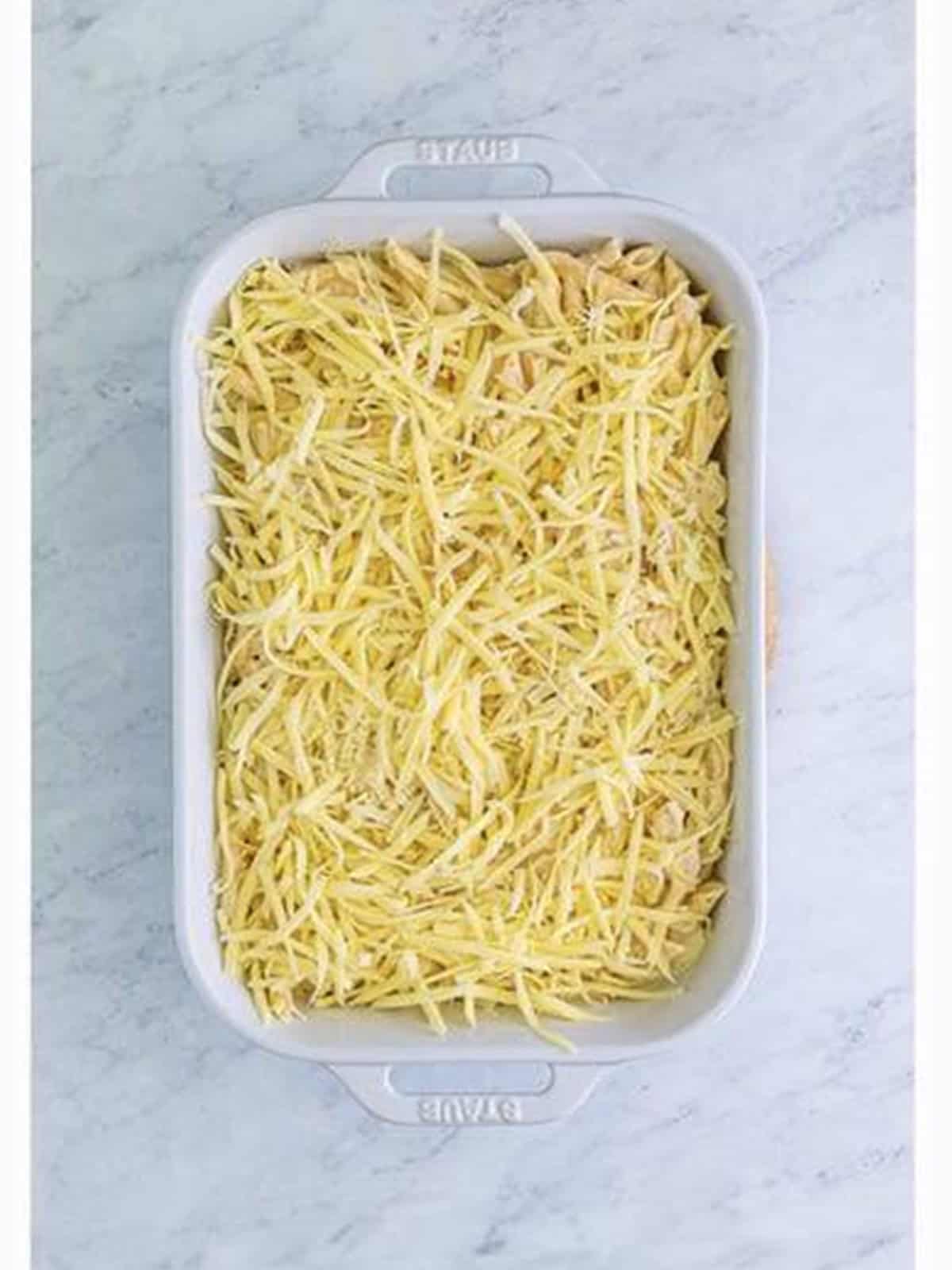 Shredded mozzarella spread over the chicken alfredo bake before baking.