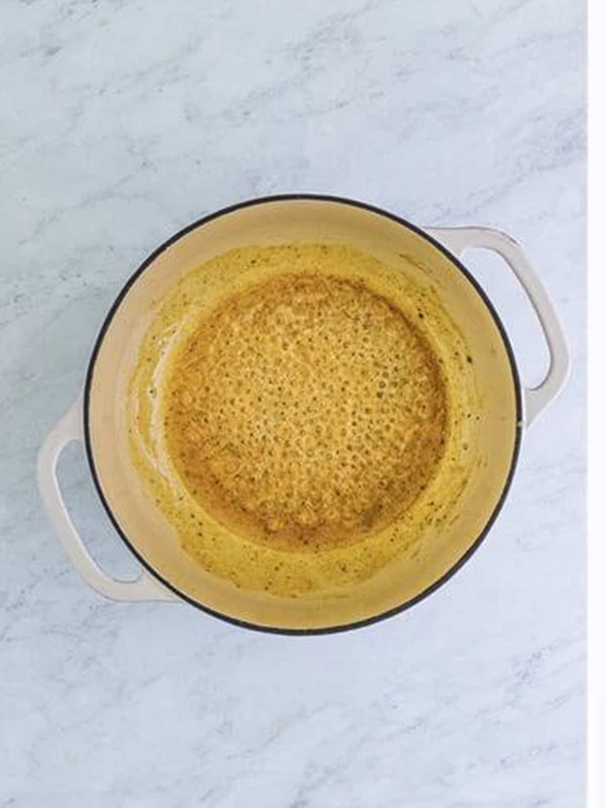 Butter and flour whisked into a roux in a pot for chicken alfredo bake.
