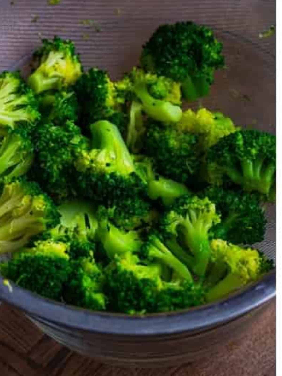 Blanched broccoli florets in a strainer for chicken broccoli alfredo.