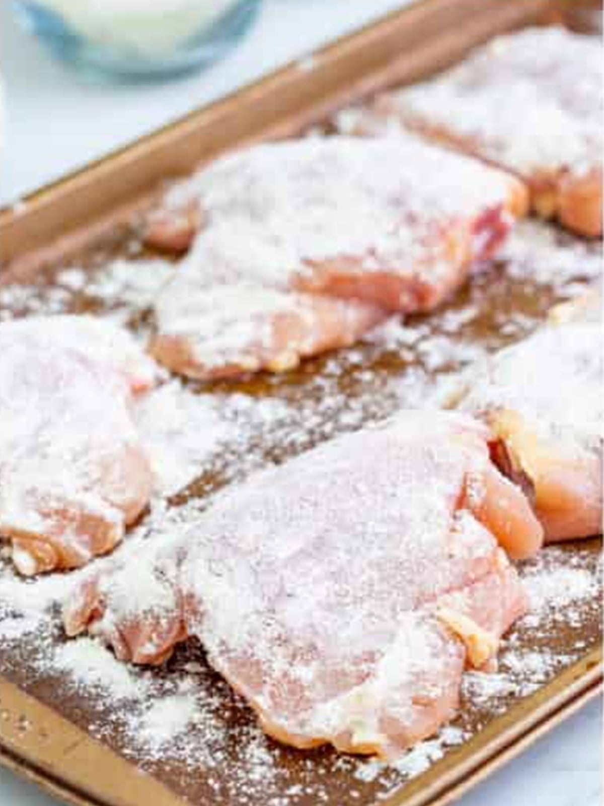 Chicken thighs dusted with flour for chicken cacciatore.