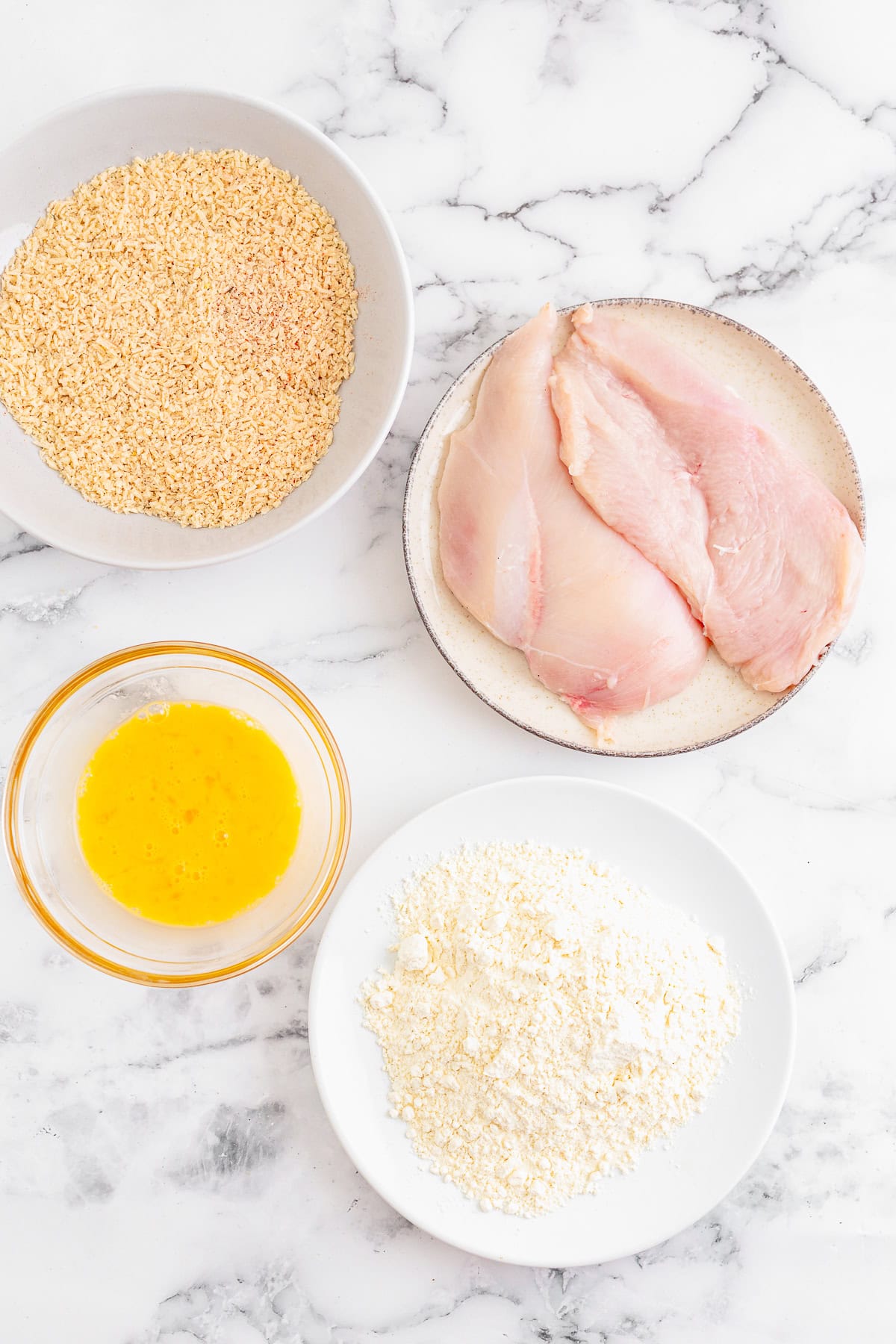 A breading station with flour, beaten egg, and seasoned panko for the Cobb Salad chicken.