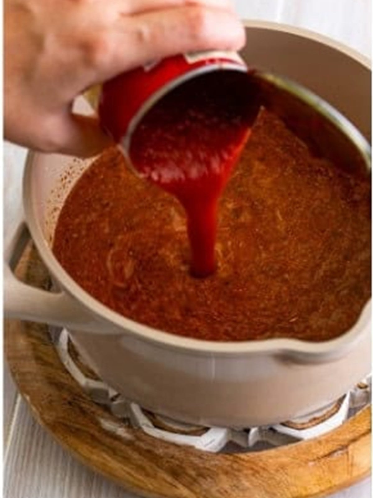 Tomato sauce poured into the thickening homemade enchilada sauce.