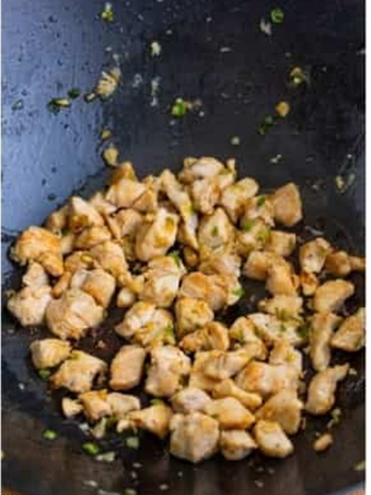 Cooking diced chicken in a hot wok
