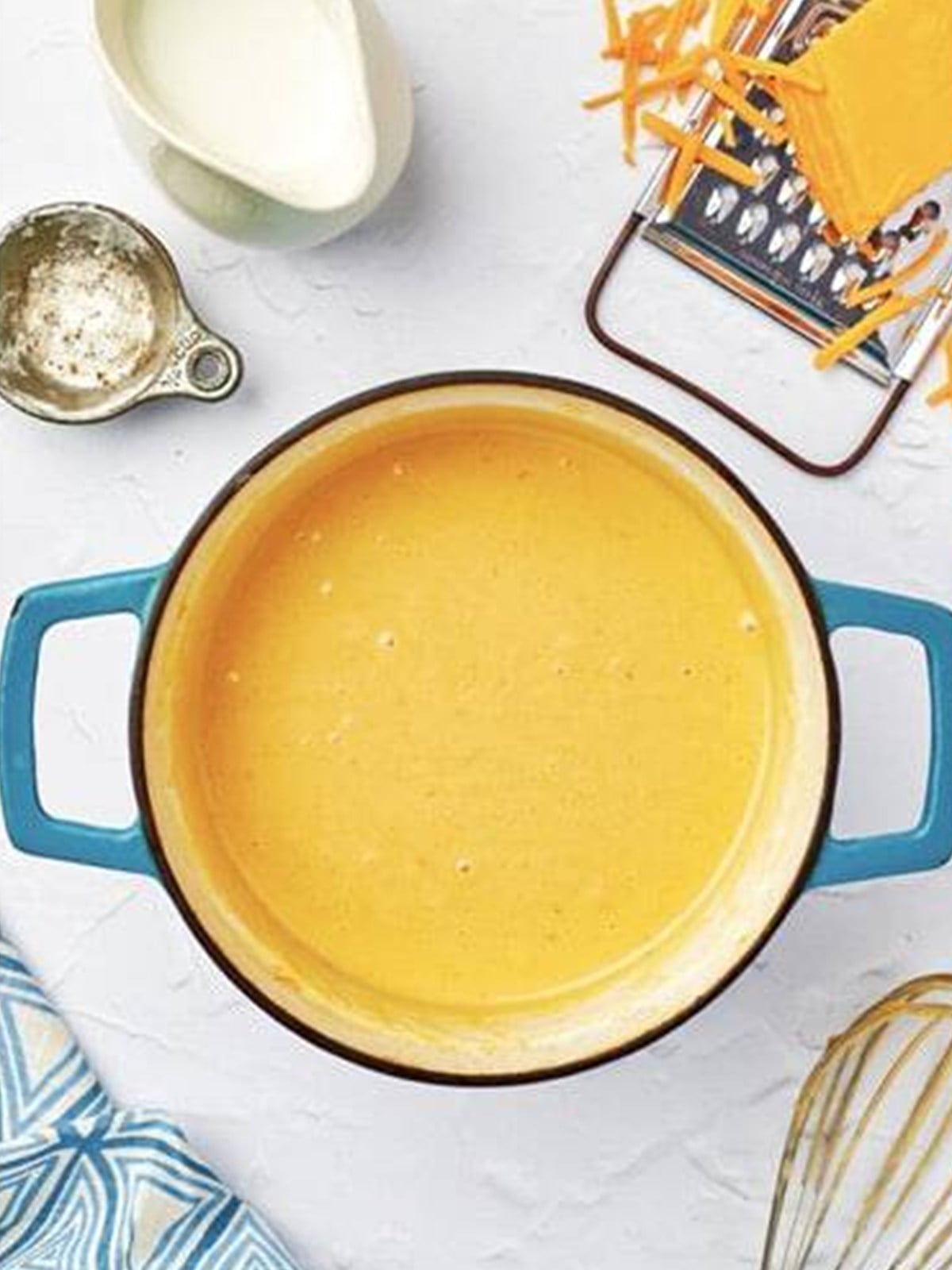 Shredded cheddar whisked into the sauce to make a smooth nacho cheese sauce.