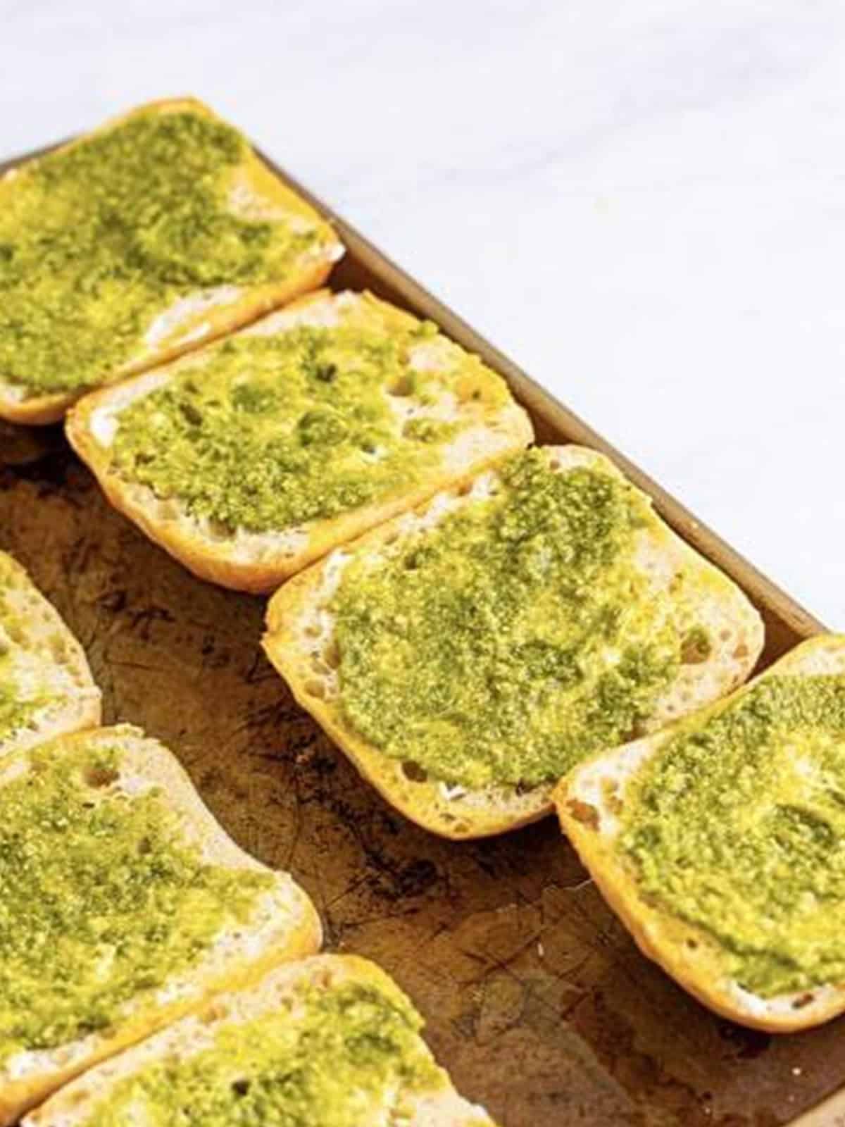 Ciabatta rolls brushed with oil and spread with mayonnaise and pesto.