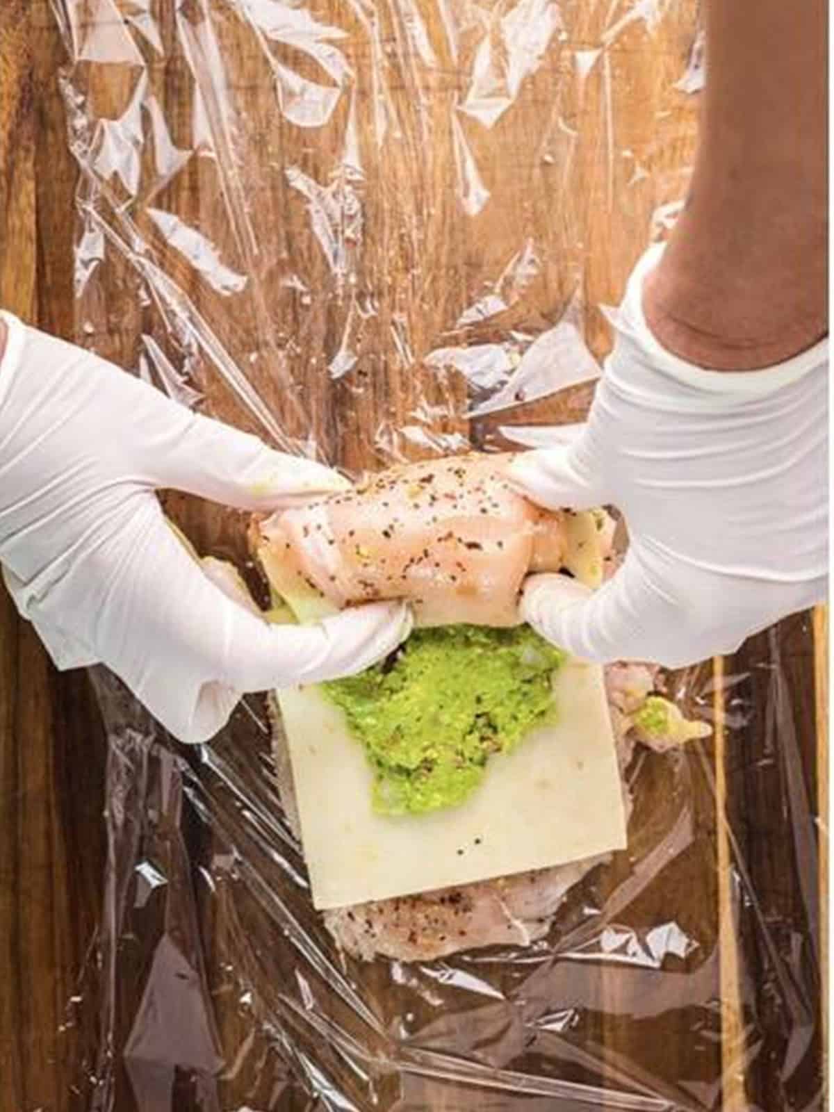 Stuffed chicken breast rolled up tightly before wrapping.