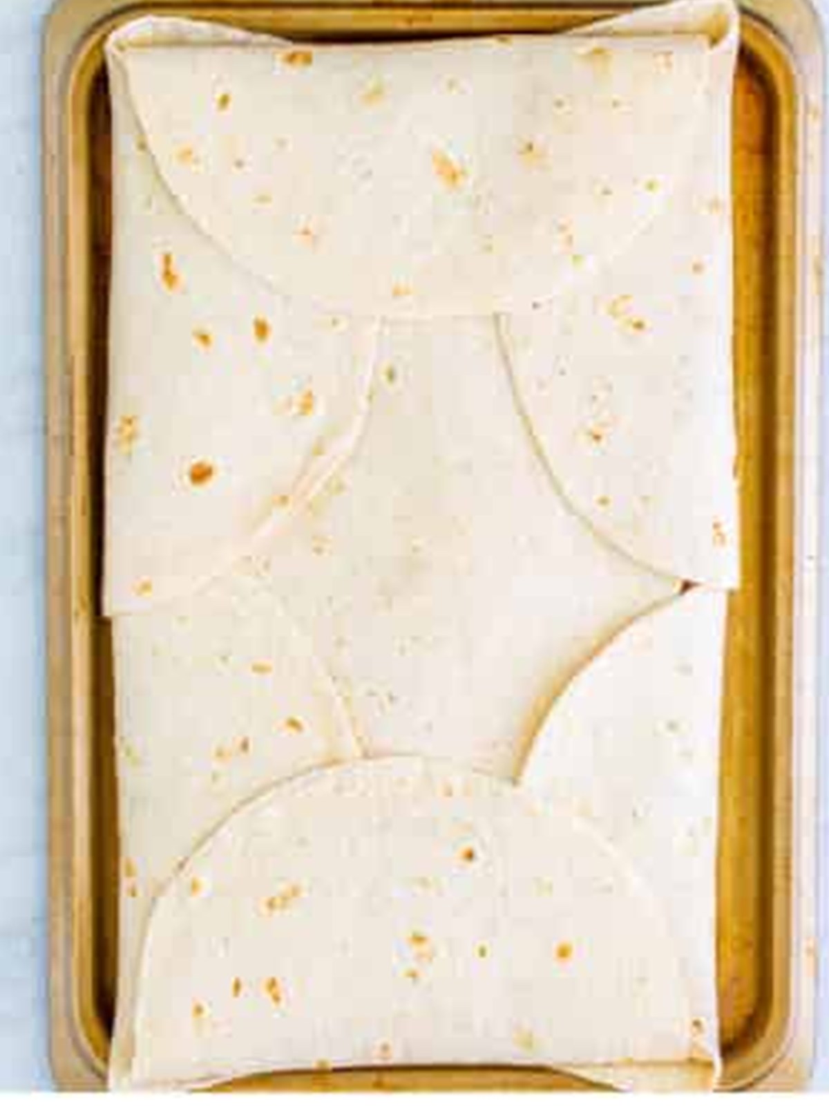 Tortillas folded over the top to enclose the sheet pan chicken quesadilla.