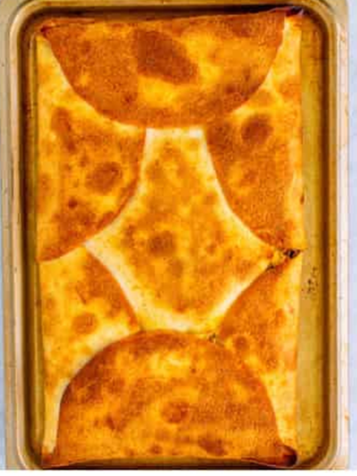 Golden baked sheet pan chicken quesadilla cut into squares.