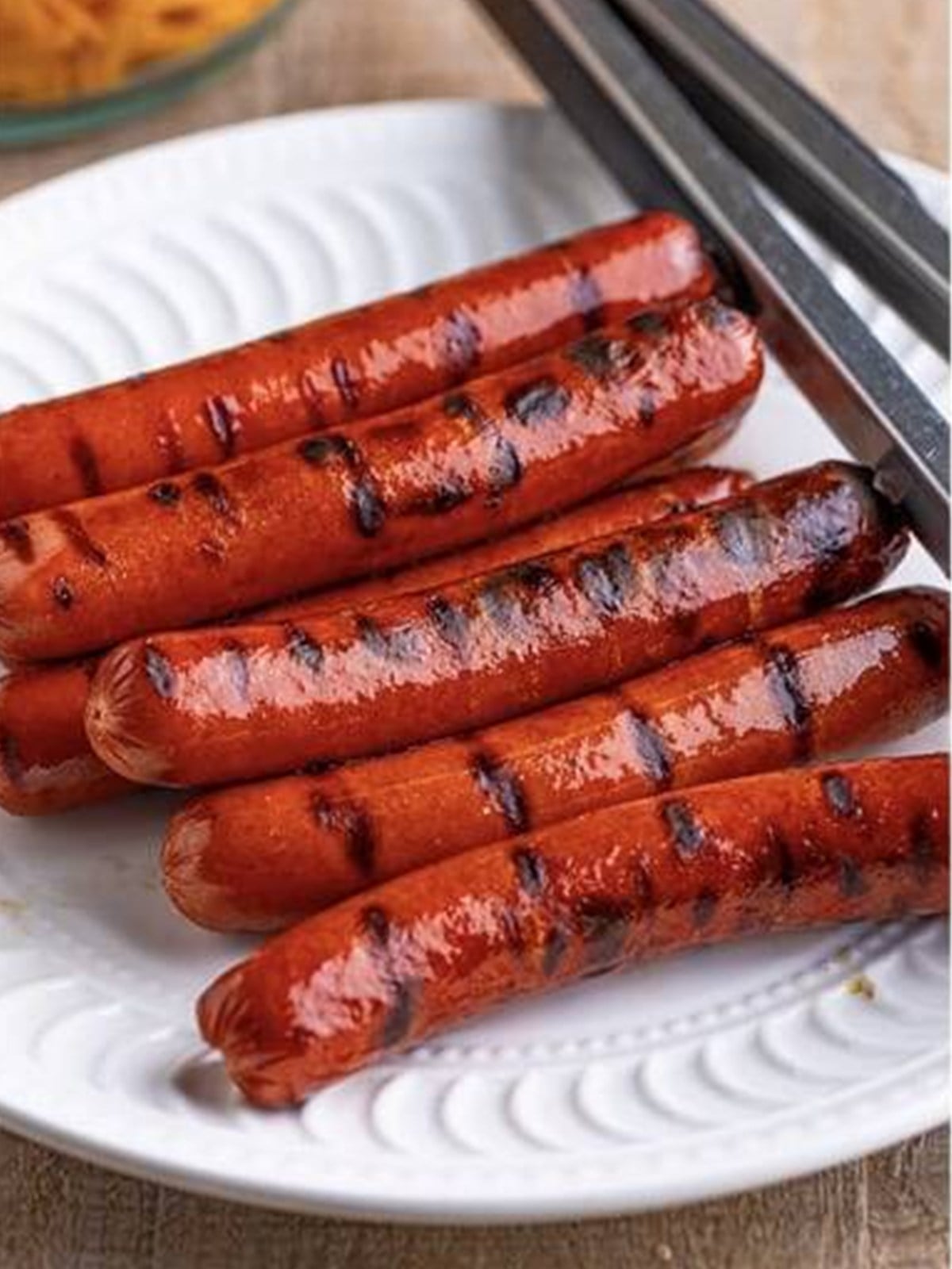 Grilled hot dogs with a char sliced for chili cheese dog mac and cheese.