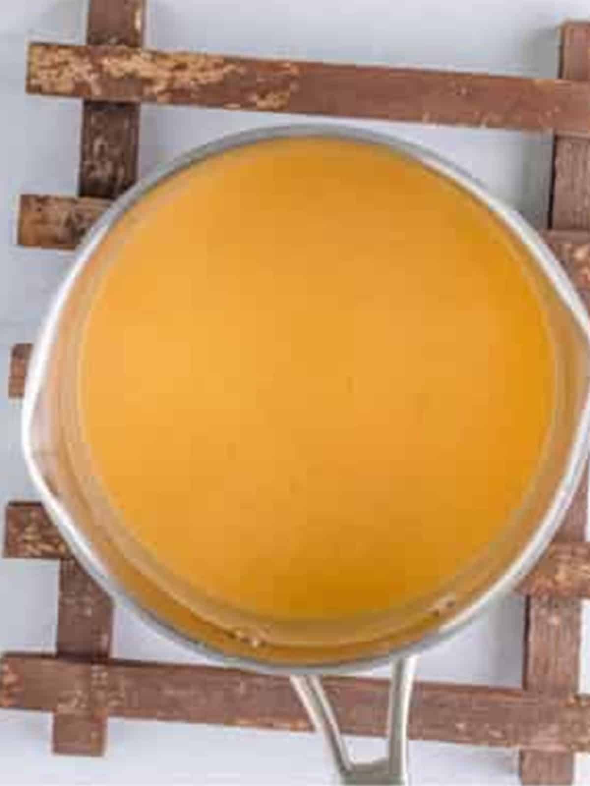 Milk streamed into the roux to make a smooth cheese sauce base.
