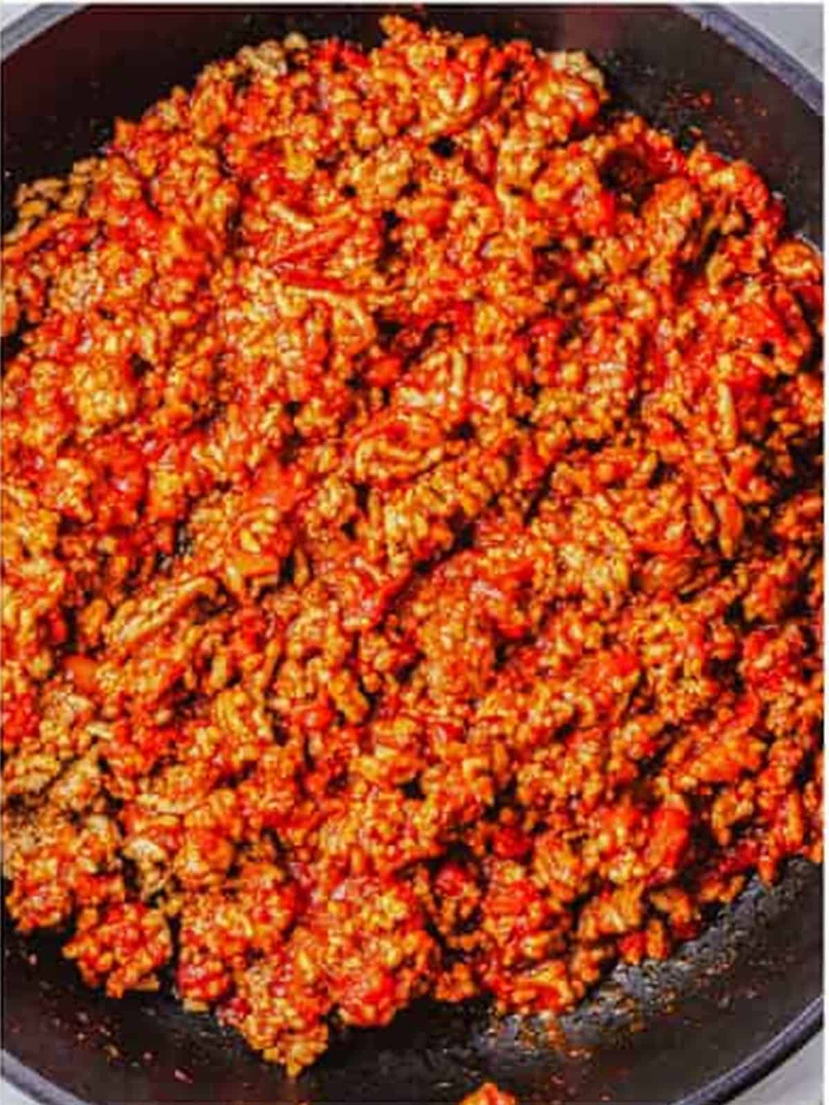 Homemade chili dog sauce simmering in a skillet.