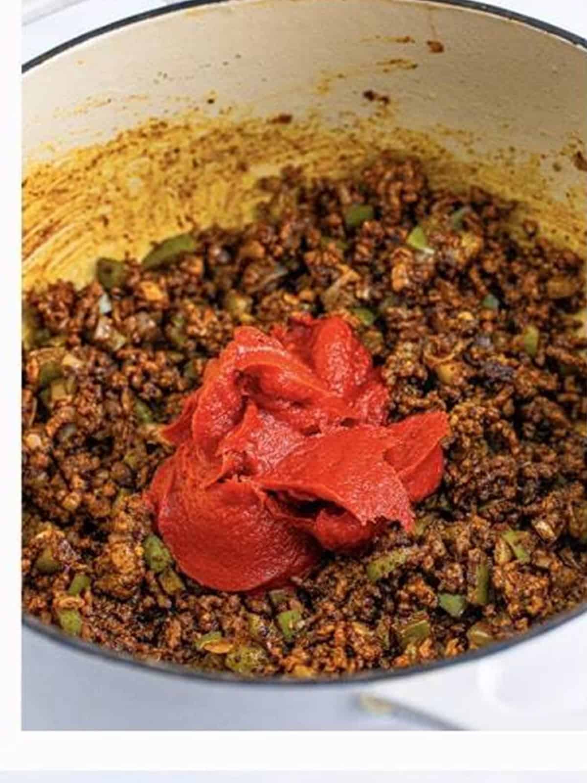 Tomato paste stirred into the seasoned beef for chili mac.