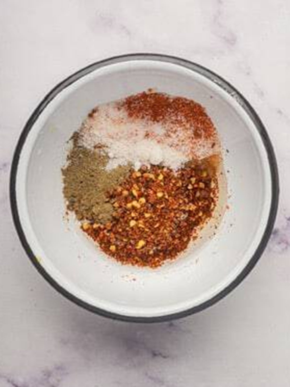 Chili flakes, paprika, salt, pepper, and sugar mixed in a heatproof bowl for chili oil.
