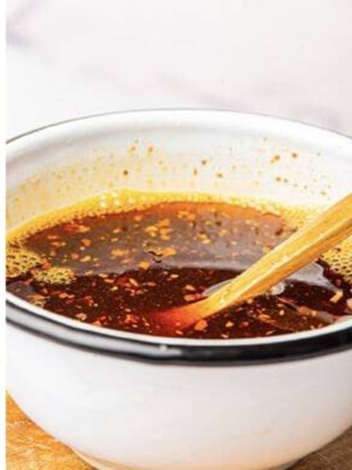 Finished homemade chili oil mixed together in a white bowl with a spoon.