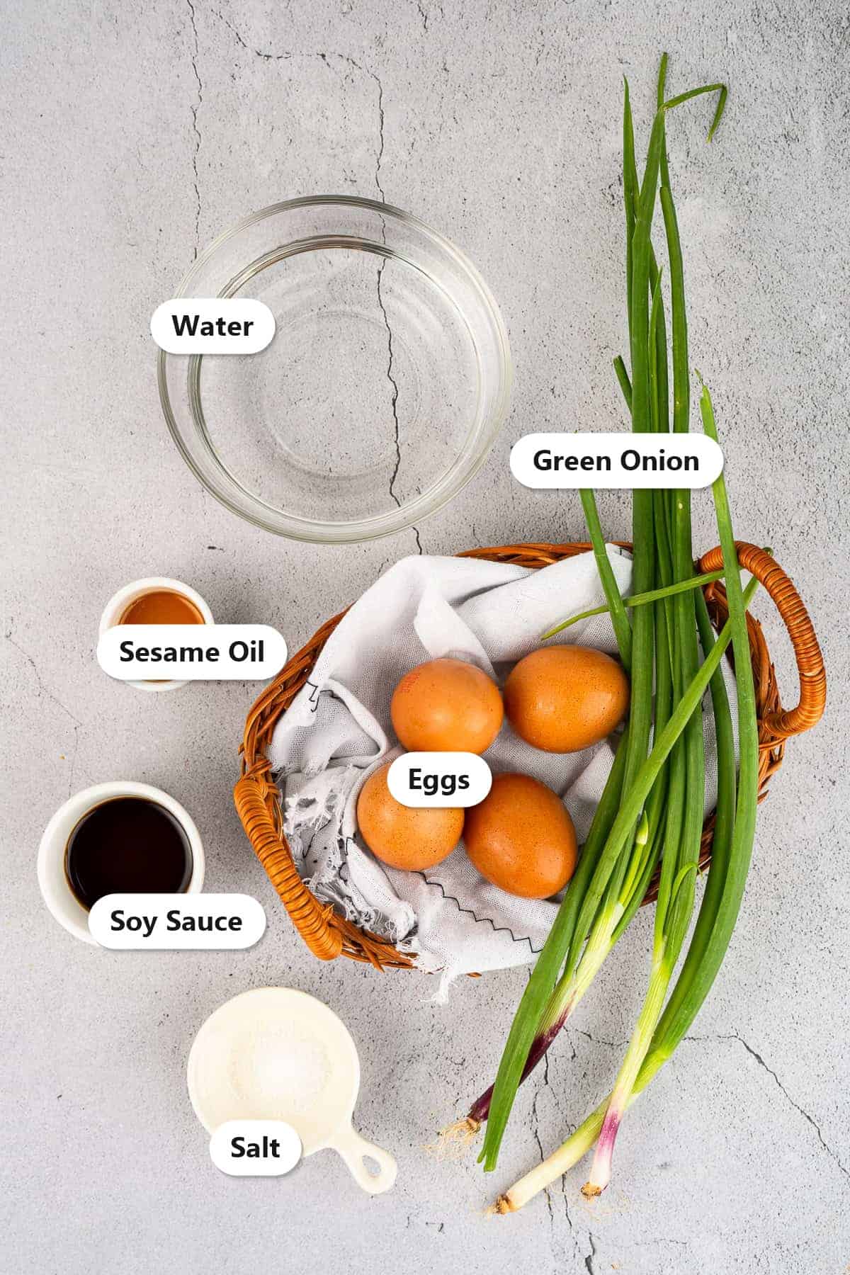 Labeled ingredients for Chinese steamed eggs including eggs, water, green onion, soy sauce, sesame oil, and salt.