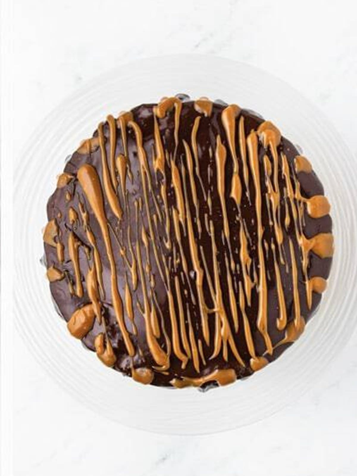 Drizzling caramel over the chocolate caramel cake.