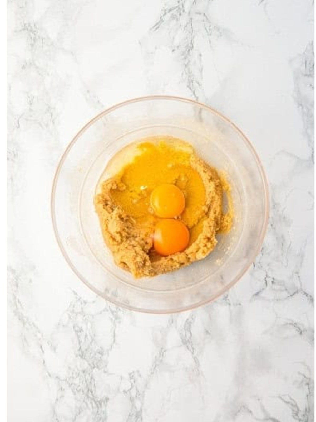 Adding eggs to the creamed butter and sugar for Chocolate Chip Cookie Bars.