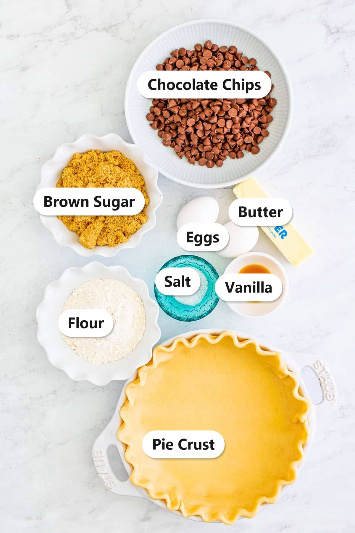 Labeled ingredients to make chocolate chip cookie pie including pie crust, brown sugar, butter, eggs, vanilla, flour, salt, and chocolate chips.