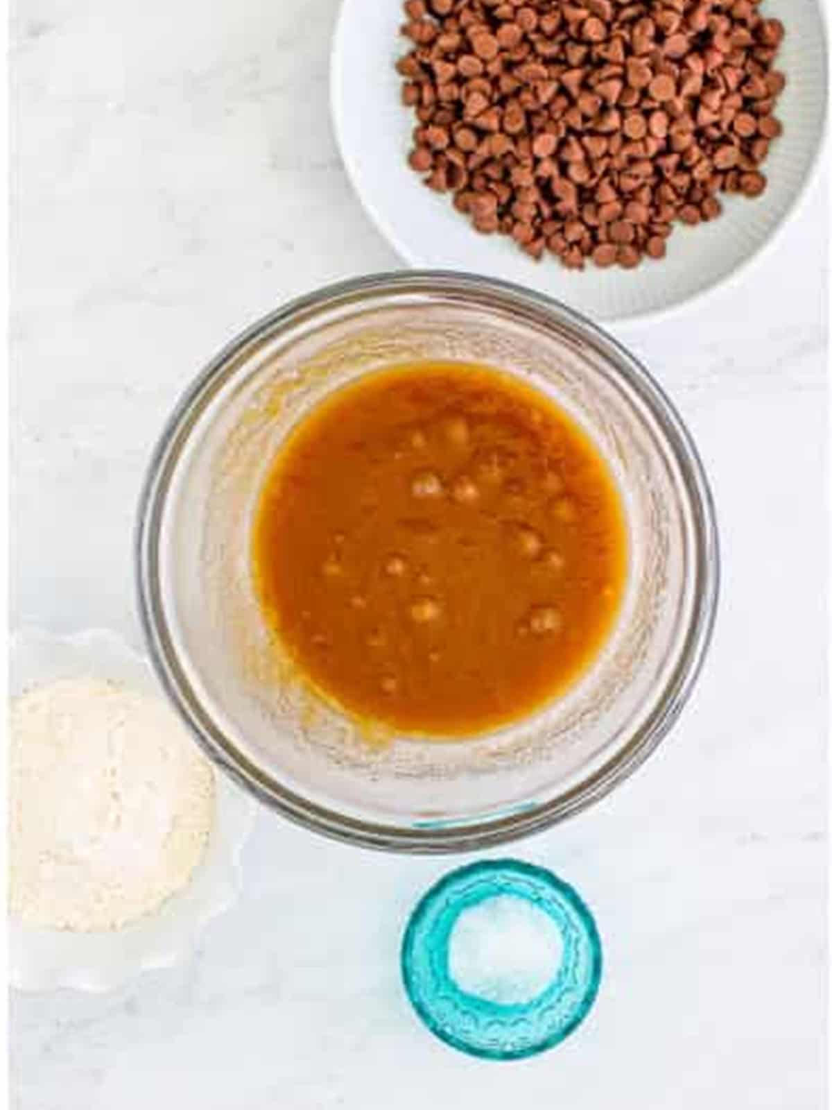 Brown sugar and melted butter whisked smooth in a glass bowl.