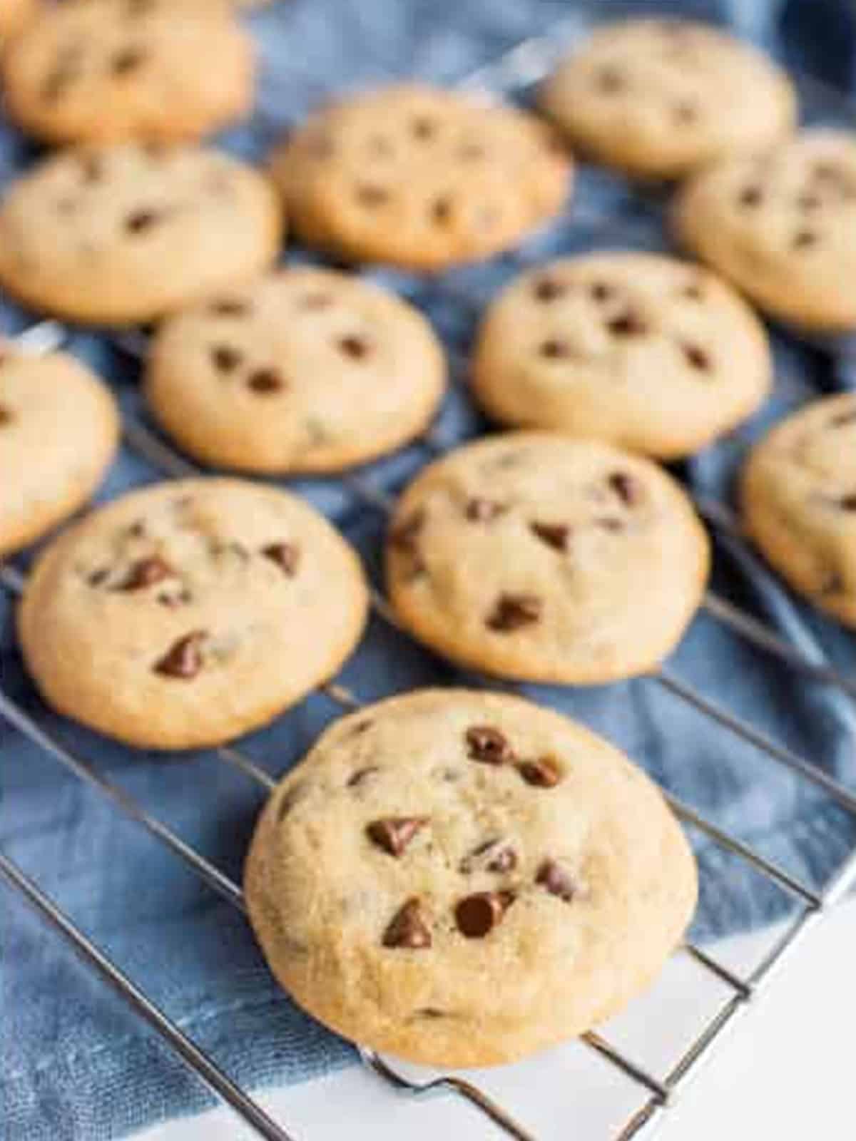 Baked chocolate chip cookies cooling on a wire rack for Chocolate Chip Cookie Sandwiches.