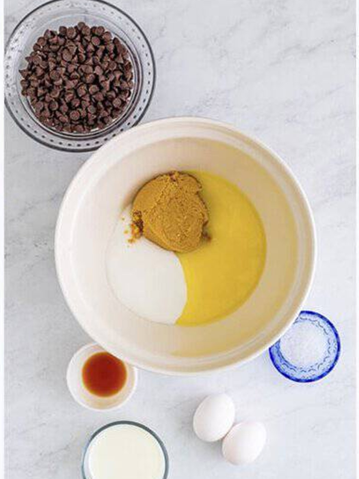 Melted butter, granulated sugar, and brown sugar in a bowl ready to whisk for chocolate chip muffins.