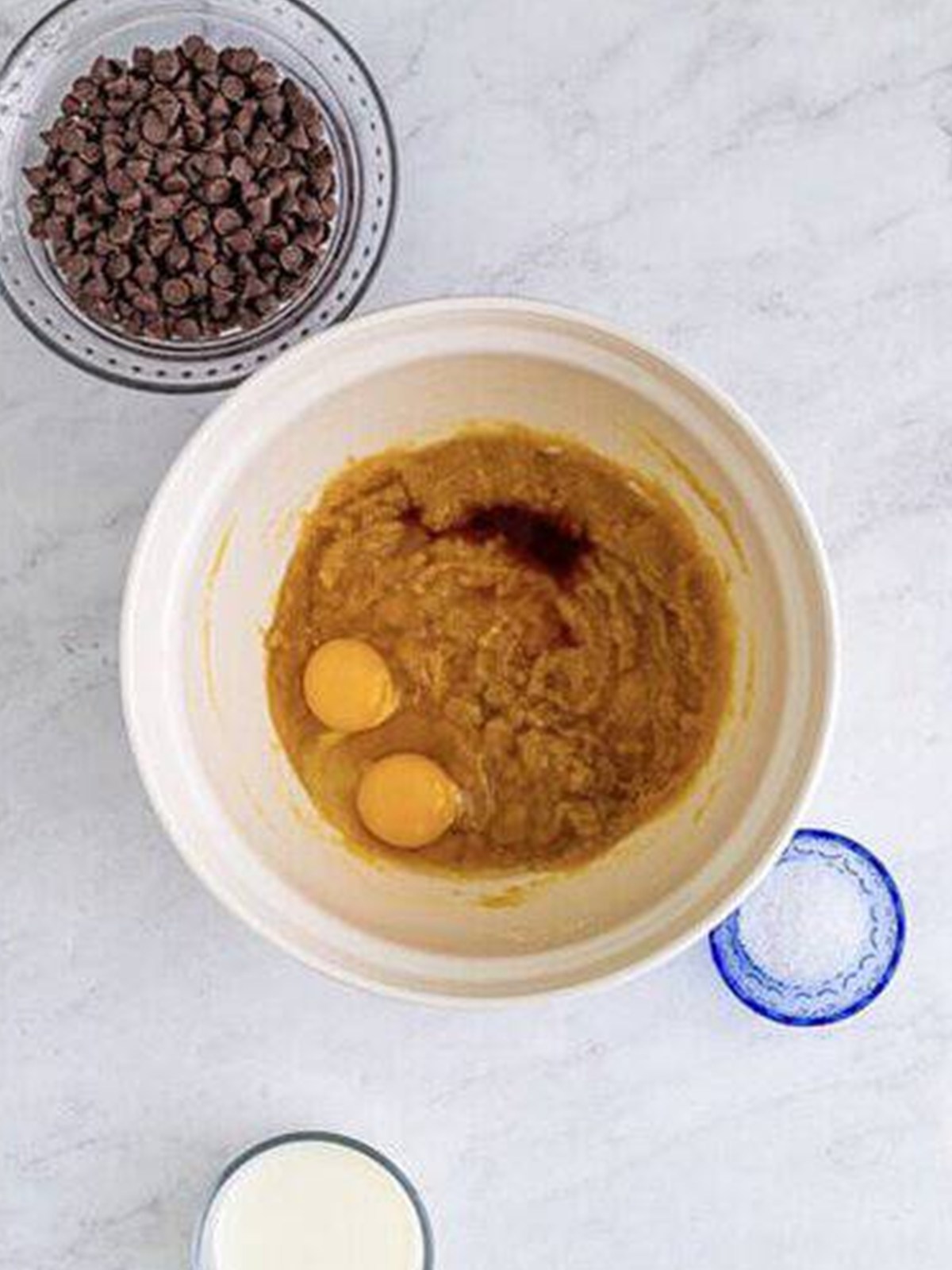 Eggs and vanilla added to the butter and sugar mixture in a bowl.