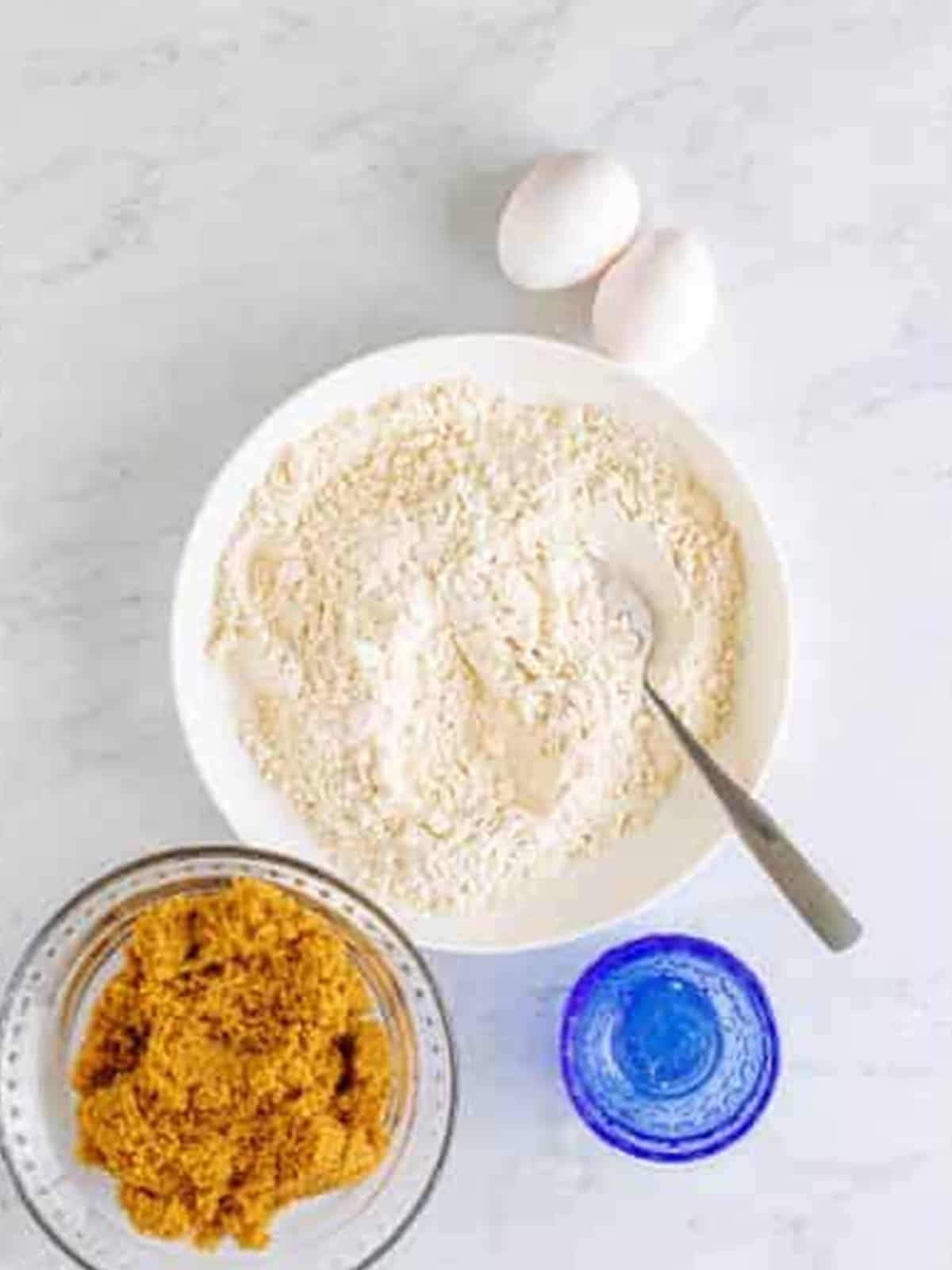 Flour, brown sugar, eggs, and salt measured out for blondies.