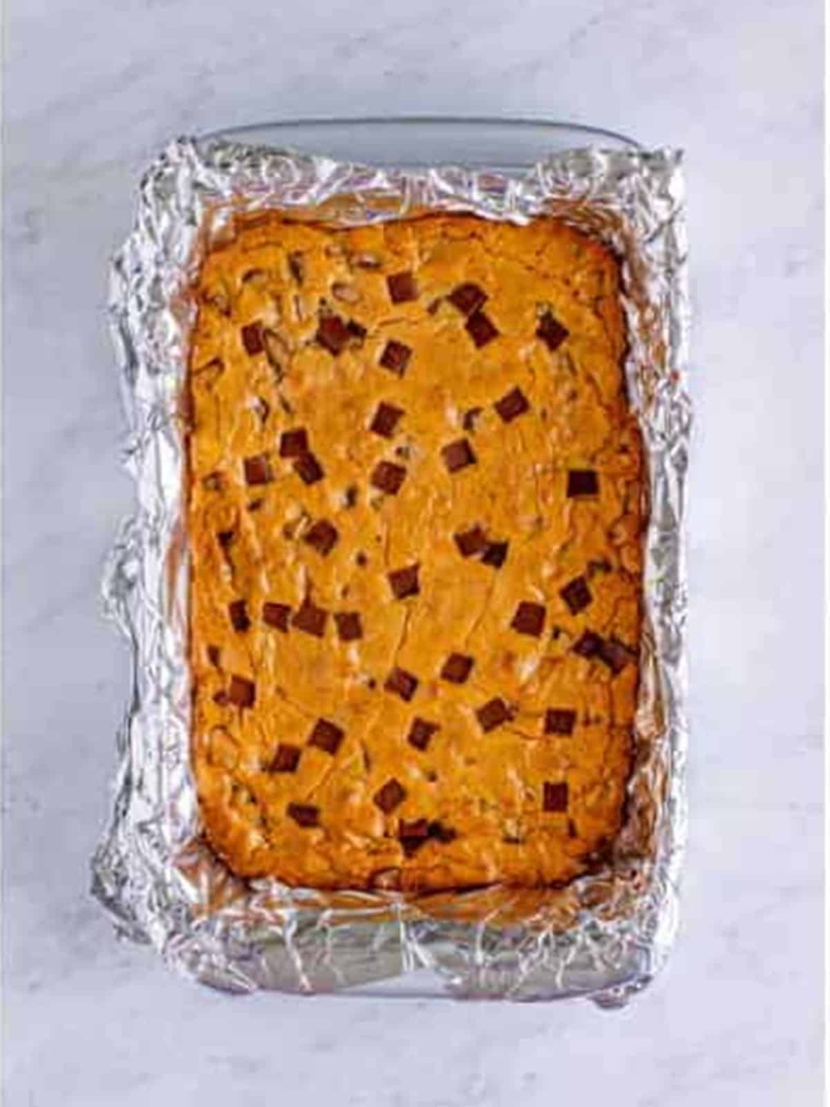 Golden baked chocolate chunk blondies in the pan.