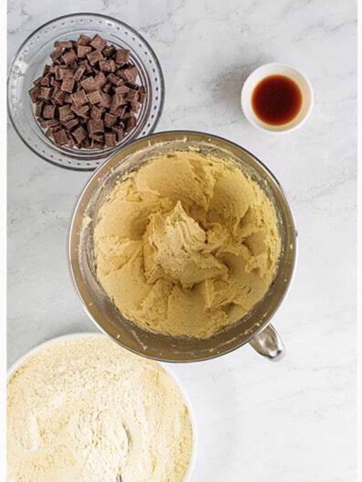 Butter and sugars creamed together in a stand mixer bowl for chocolate chunk cookies.